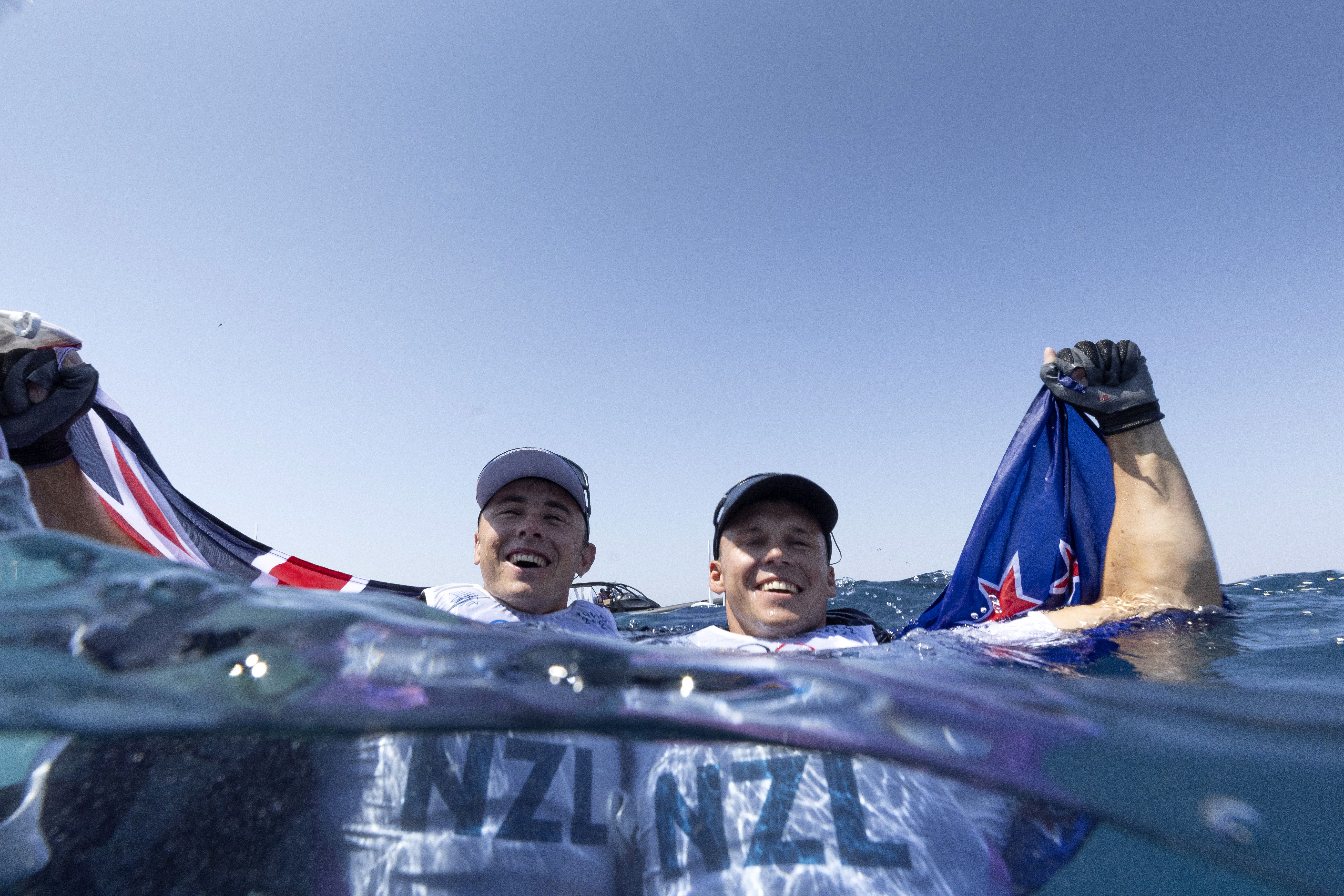 Isaac McHardie and William McKenzie take a celebratory swim after winning silver in the men's skiff 49erFX class at the Paris Olympics. Photo / Getty Images