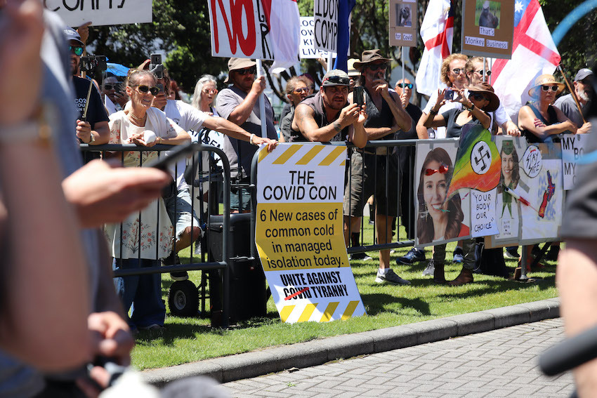 Protestors hold signs alleging Covid-19 is a scam at a rally of conspiracy theorists and supporters of US President Donald Trump on January 14, 2021 in Wellington. Photo / Getty Images