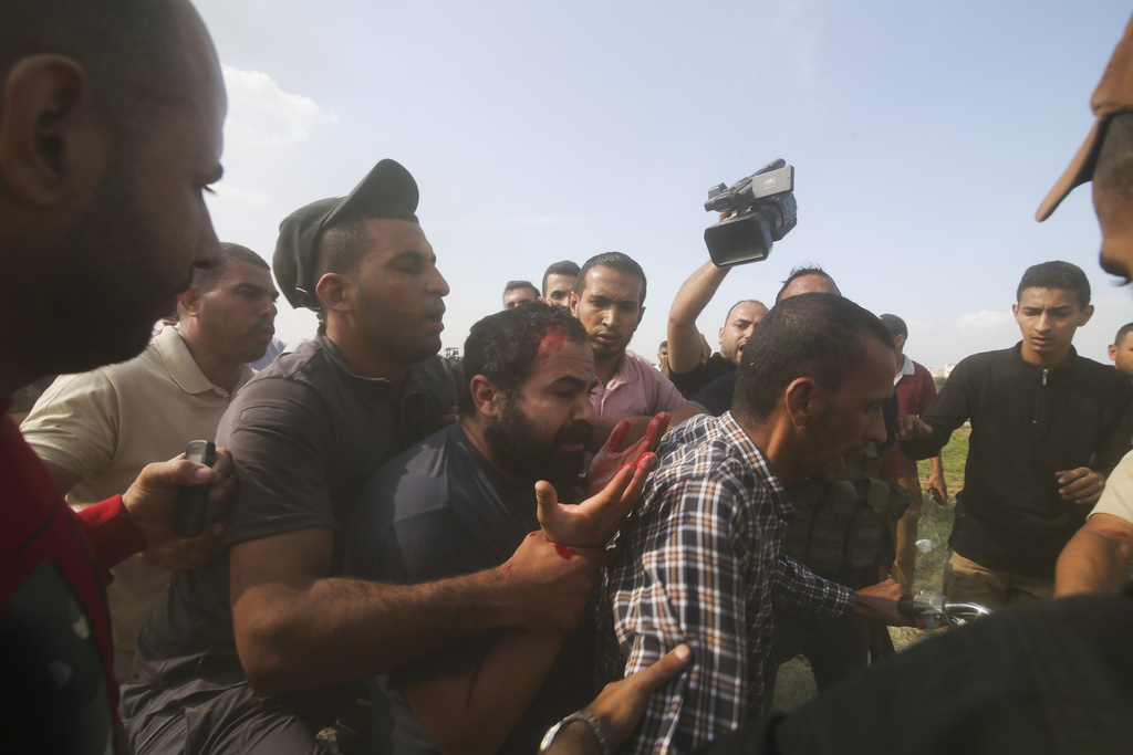Palestinians transport a captured Israeli civilian, centre, from Kibbutz Kfar Azza into the Gaza Strip on Saturday. The militant Hamas rulers of the Gaza Strip carried out an unprecedented, multi-front attack on Israel at daybreak on Saturday, firing thousands of rockets as dozens of Hamas fighters infiltrated the heavily fortified border in several locations by air, land, and sea and catching the country off-guard on a major holiday. (AP Photo/Hatem Ali)