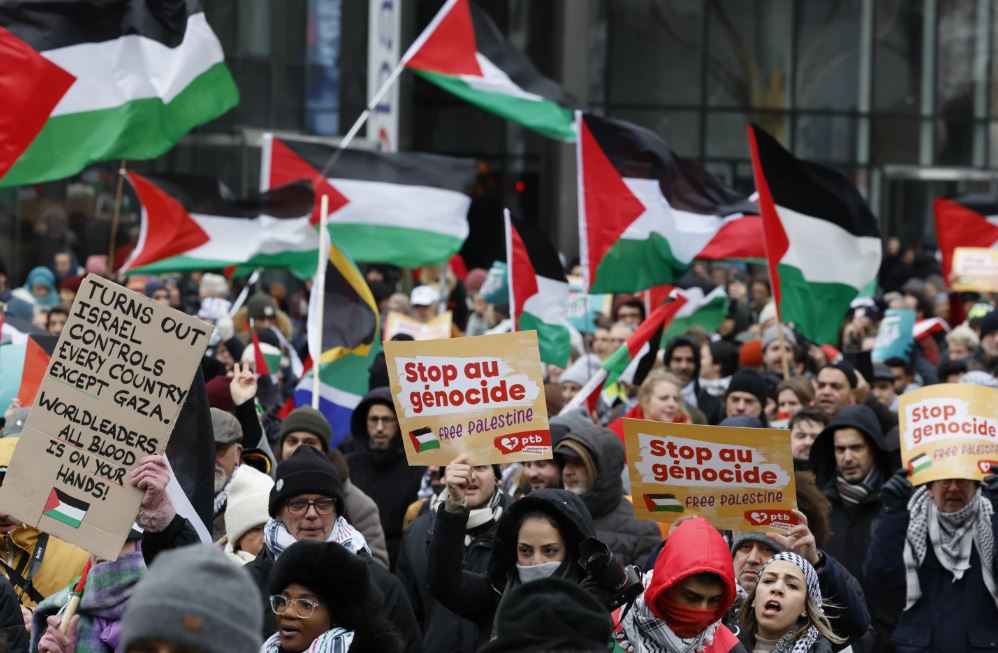Demonstrators hold signs and wave flags during a pro-Palestinian rally in Brussels. Photo / AP