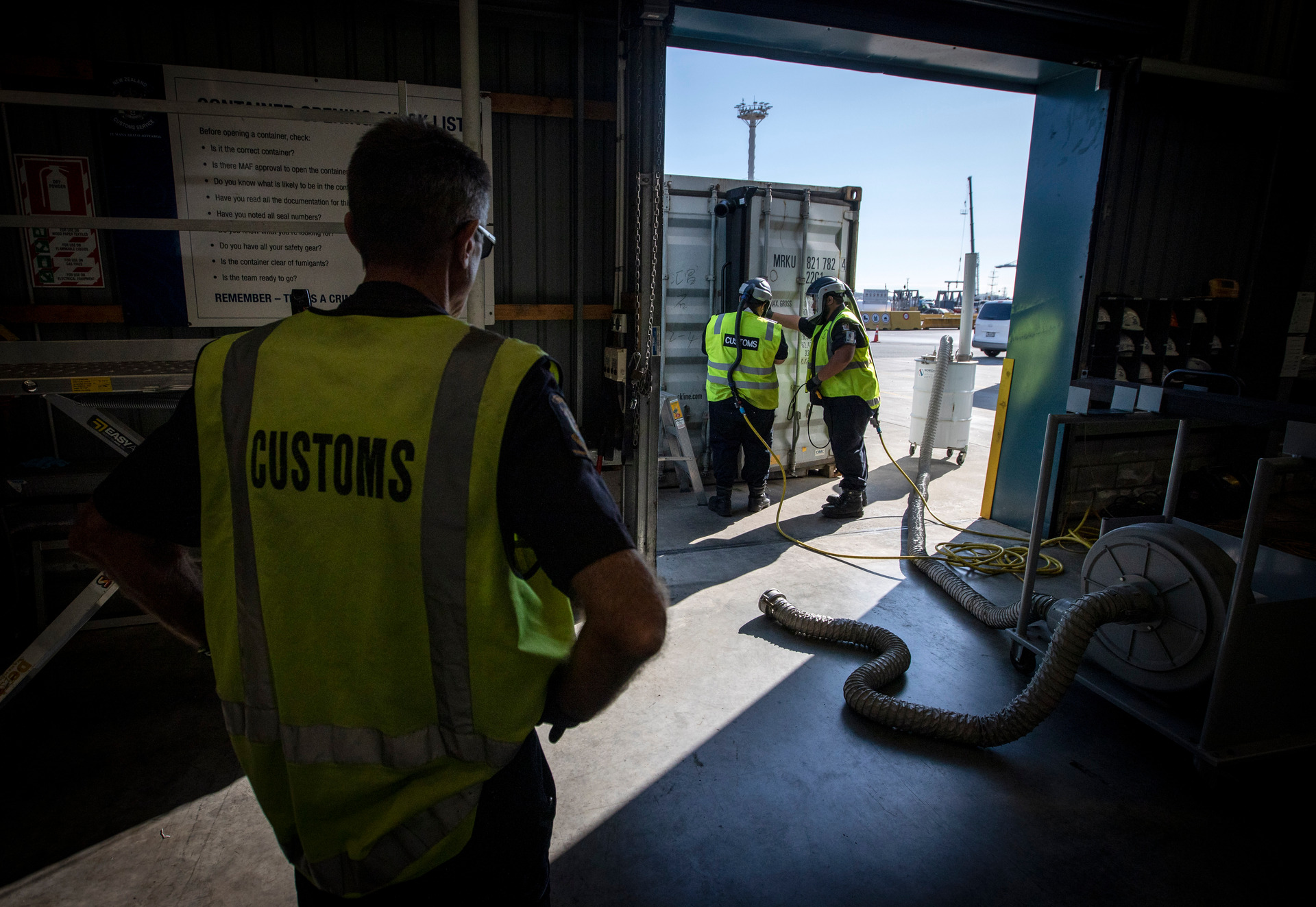 Customs staff based at the Ports of Auckland open up a container for inspection. Photo / Mike Scott