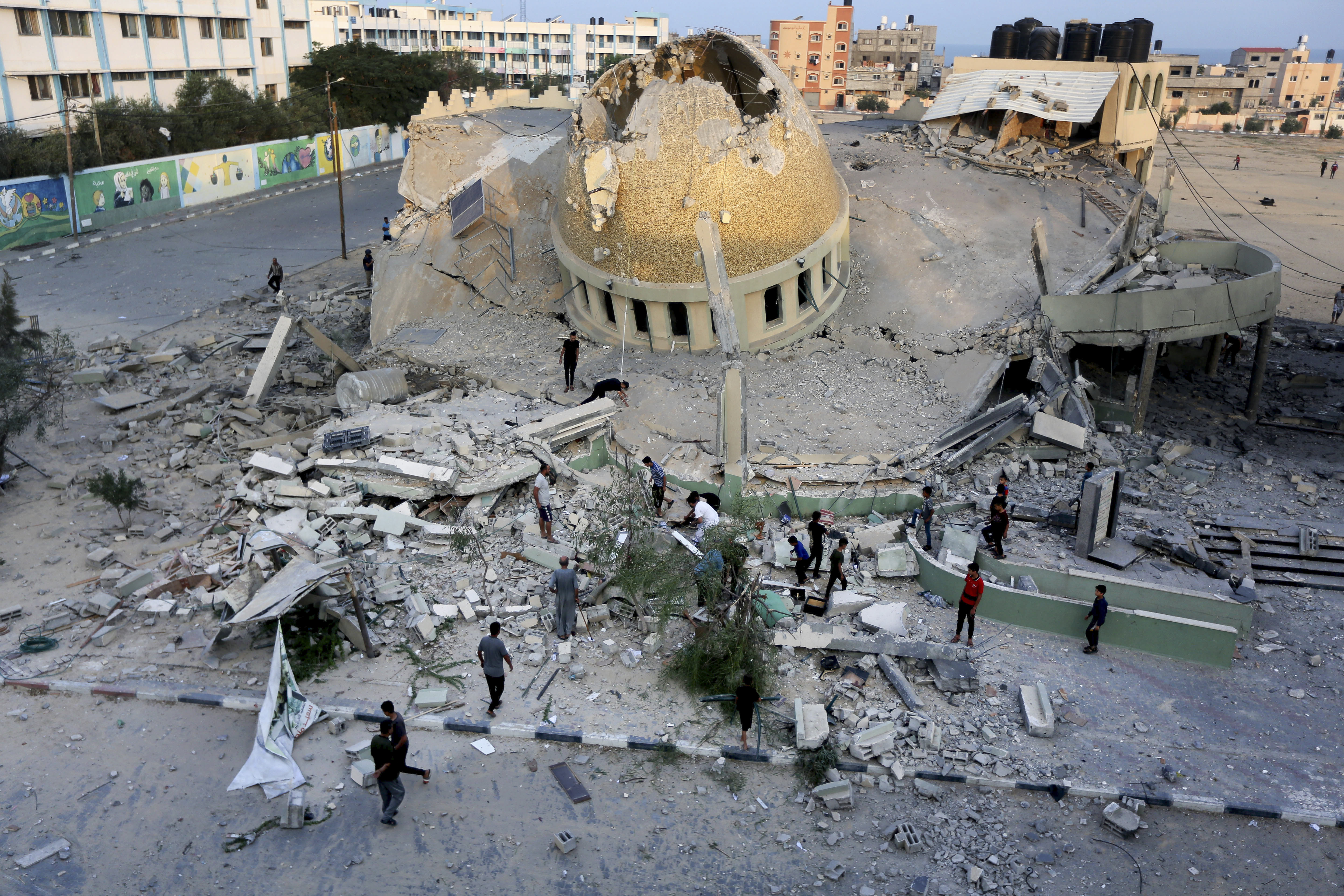 People stand outside a mosque destroyed in an Israeli air strike in Khan Younis, Gaza Strip on Sunday. Photo / AP