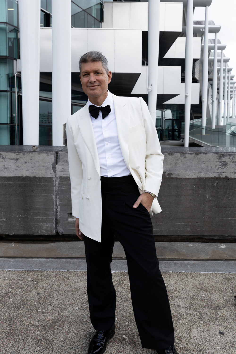 Jesse Mulligan in a custom-made ivory tuxedo jacket by Wynn Hamlyn with wide trousers, black tie and cummerbund. Photo / Katie Begbie