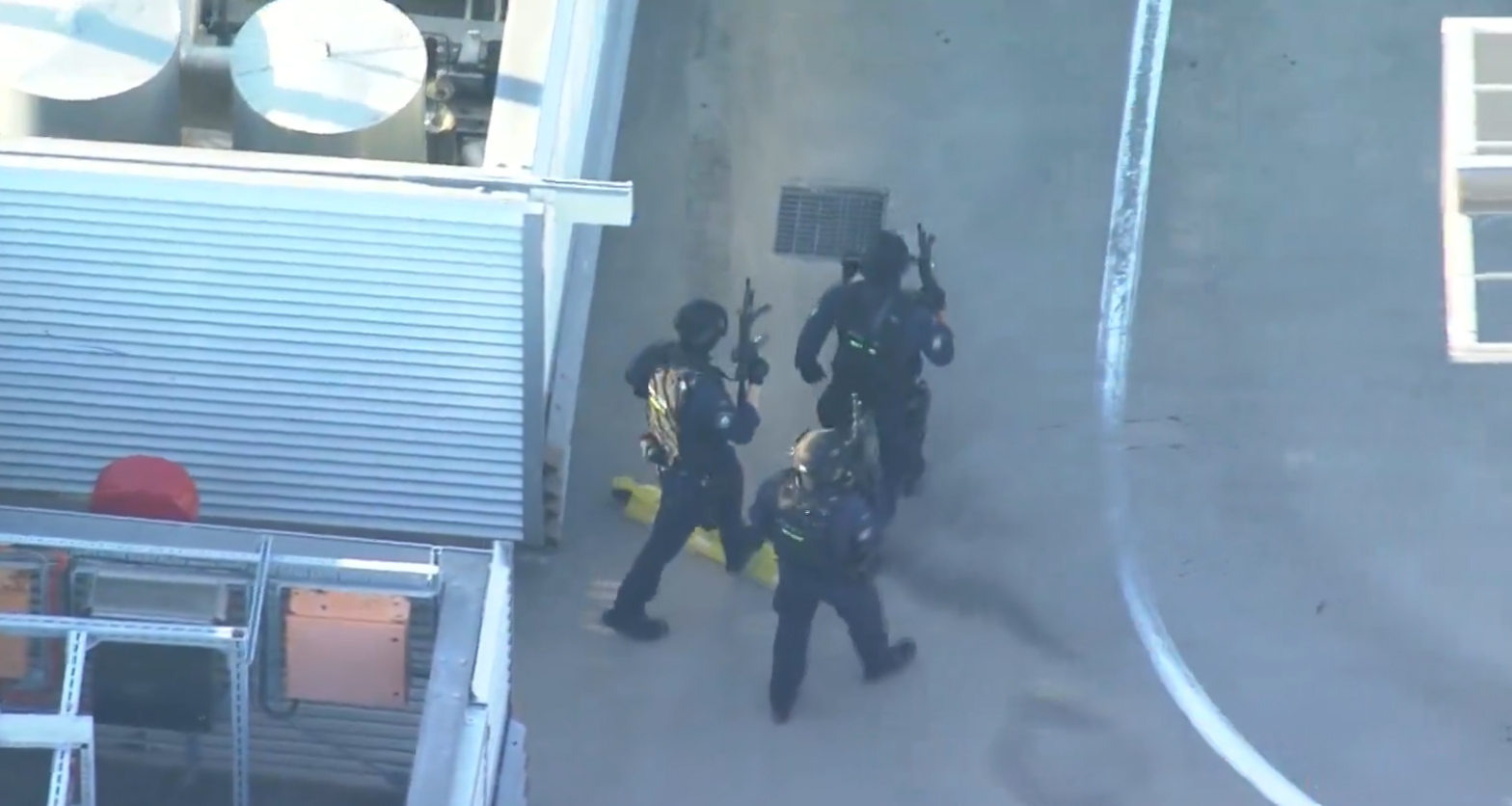 Still taken from 9News coverage showing heavily armed police entering Bondi Westfield from the roof. Photo / 9News