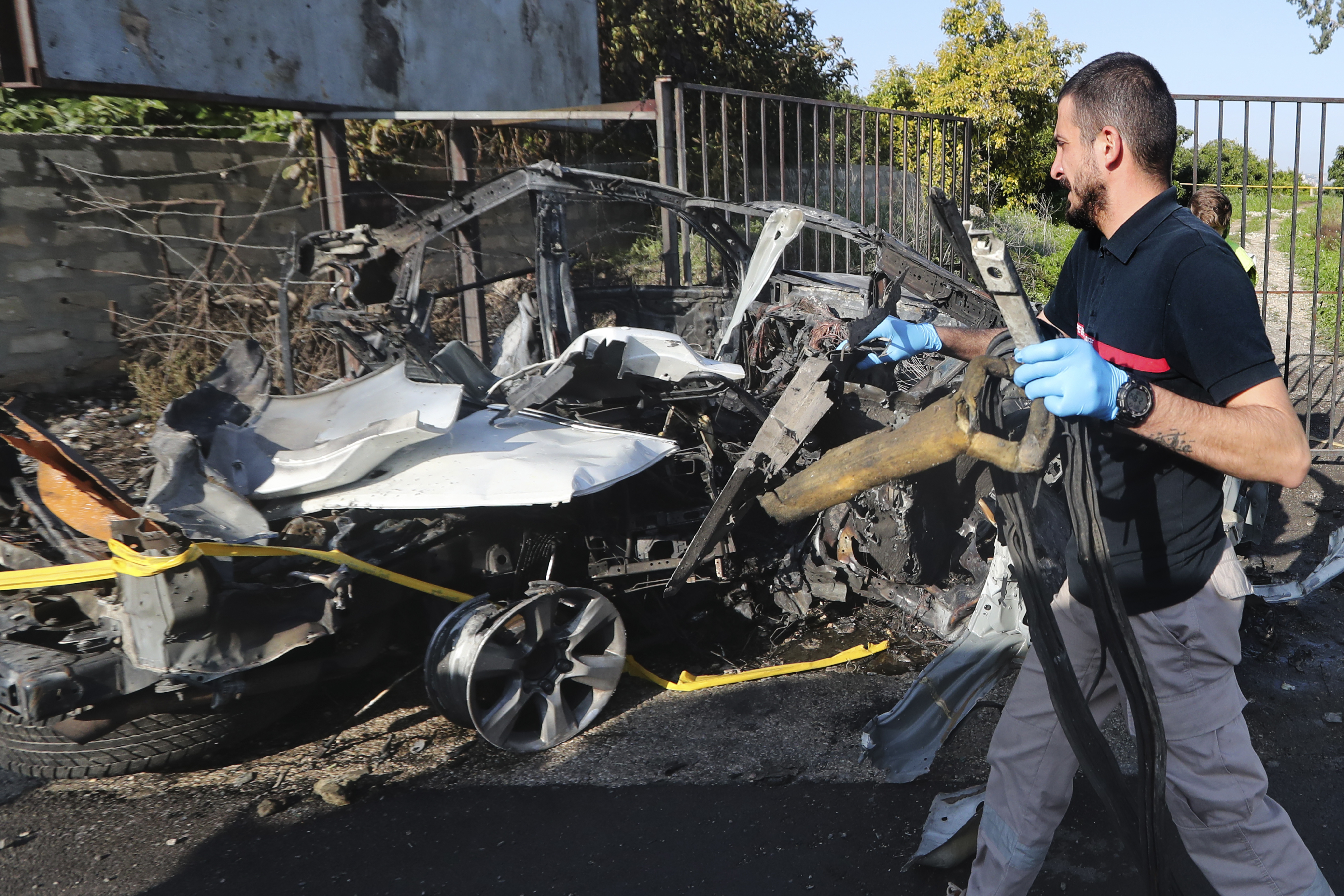 A civil defence worker carries parts of a destroyed car in the southern town of Bazouriyeh, Lebanon on January 20. Photo / AP