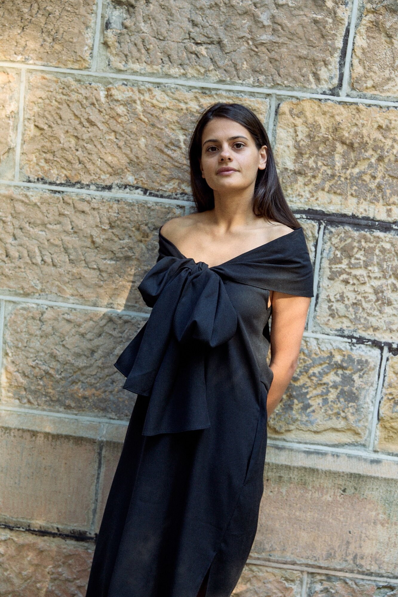 A black full-length dress with the shoulder sash tied.