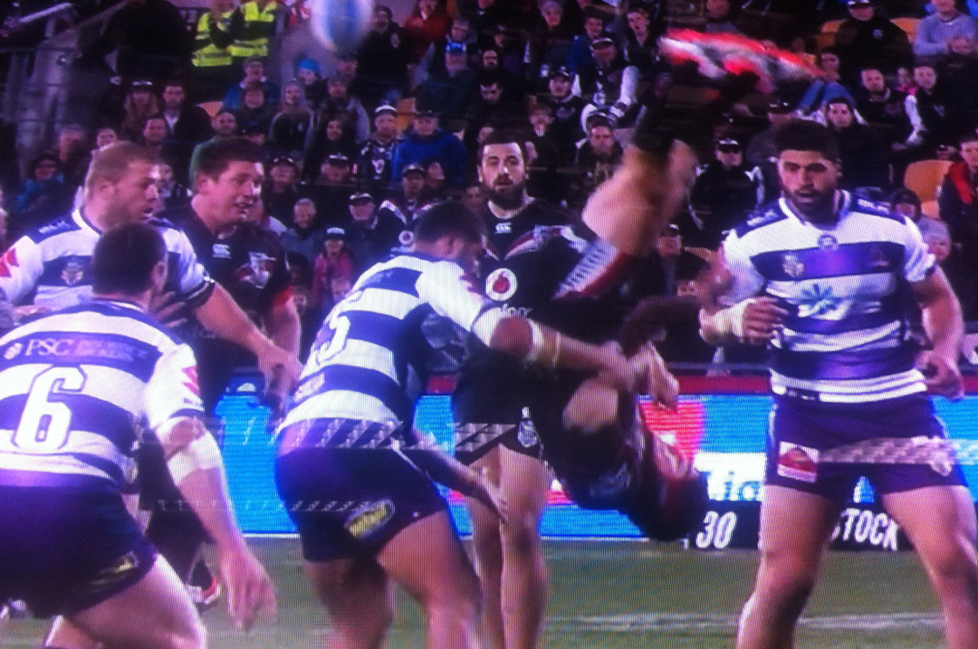 Nathan Friends flicks the ball back while falling in a tackle.