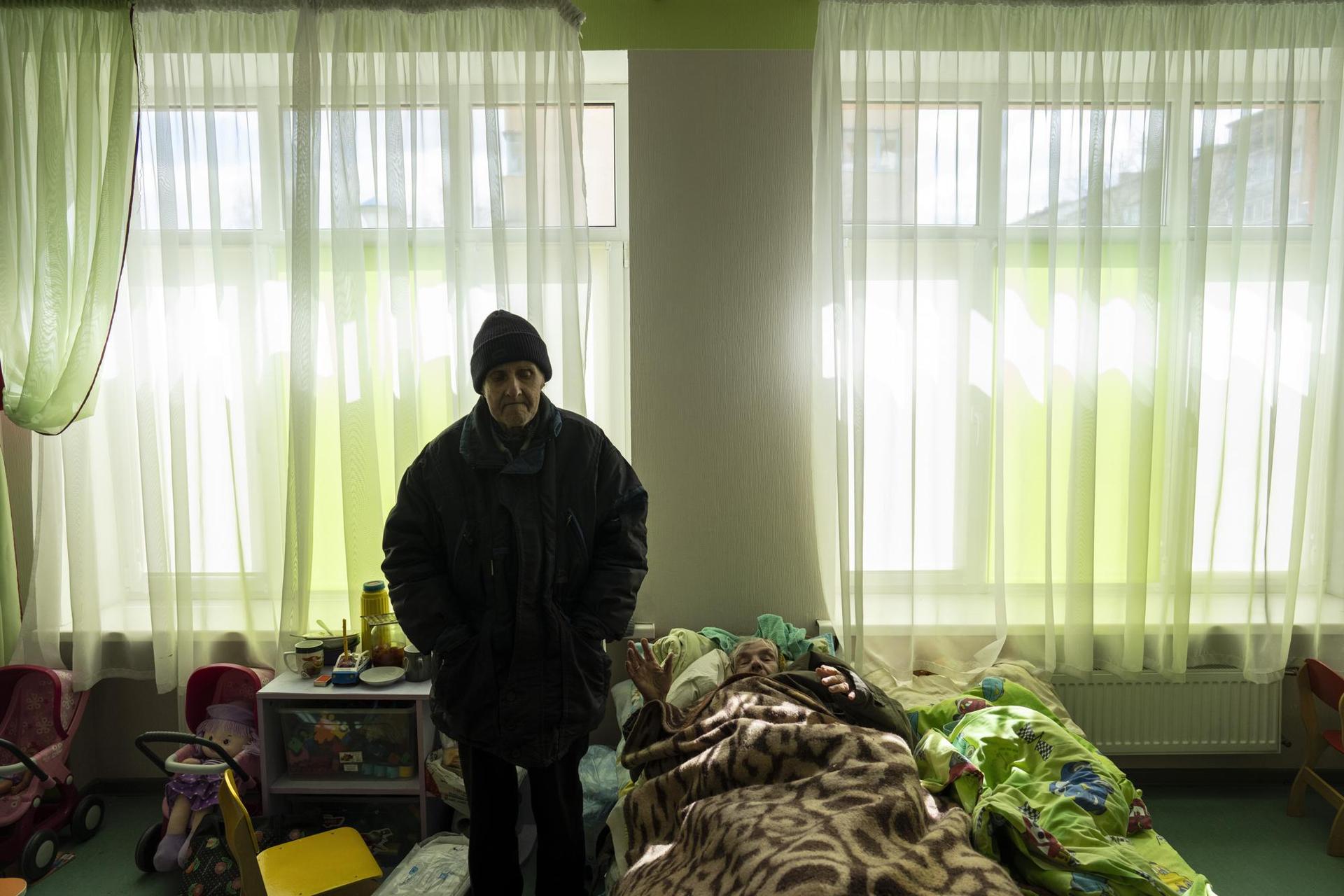 Nina Kirinchenko, 90, greets journalists next to her husband in part of a building that was converted as housing for 400 people, since apartments were used by Russian soldiers. Photo / AP