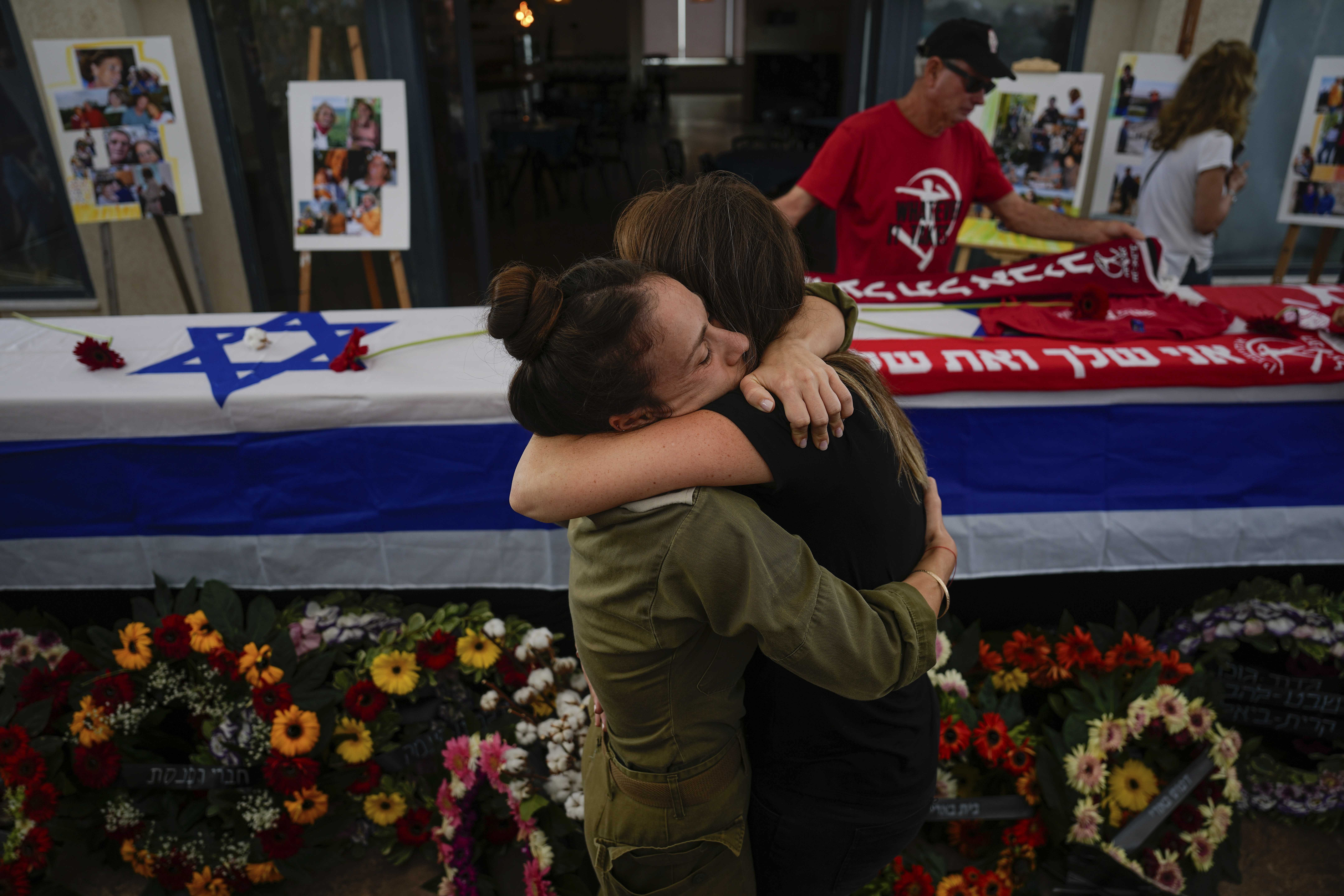 FILE - Mourners embrace during the funeral of Meni and Ayelet Godard, in Kibbutz Palmachim, Israel Sunday, October 29, 2023. Israel and Hamas have been at war for 100 days. The war already is the longest and deadliest between Israel and the Palestinians since Israel’s establishment in 1948, and the fighting shows no signs of ending. (AP Photo/Ariel Schalit, File)