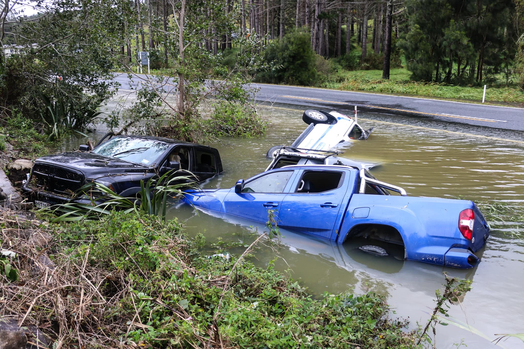 Vehicles claimed by Whakapara's floodwaters. Photo / Jay's Photography