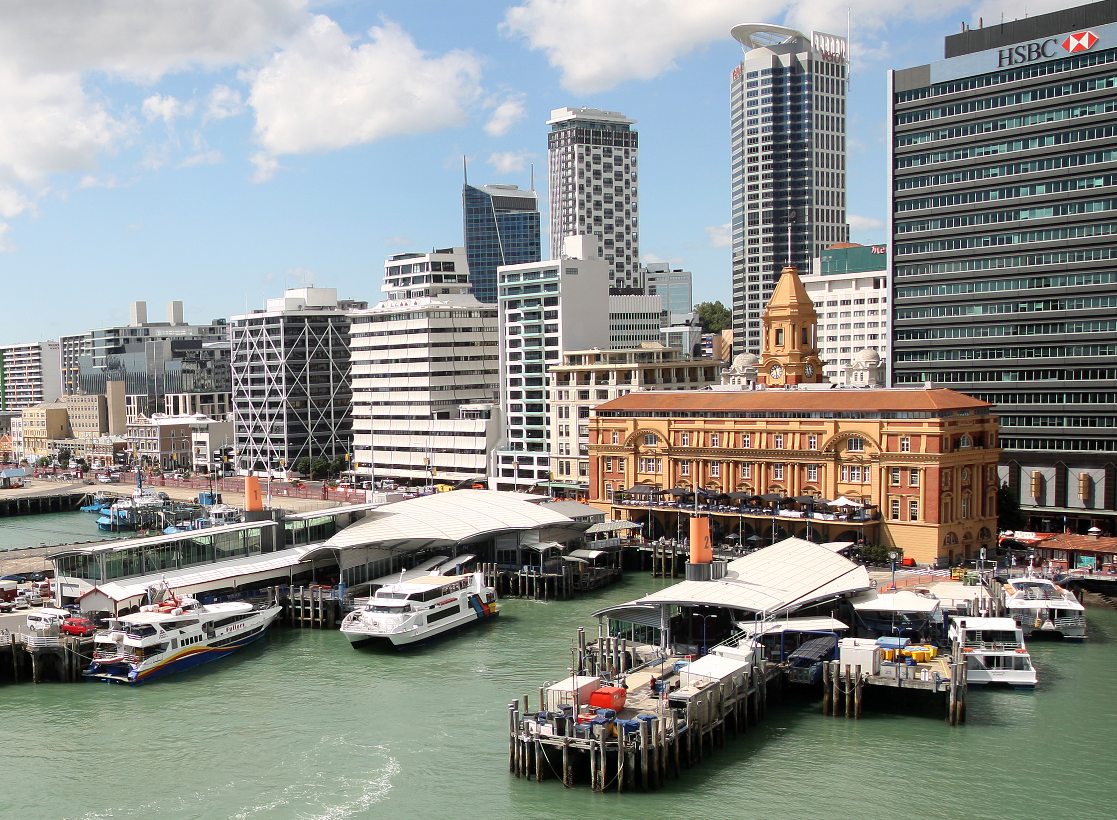 The Ferry Building is overshadowed by modern buildings. 