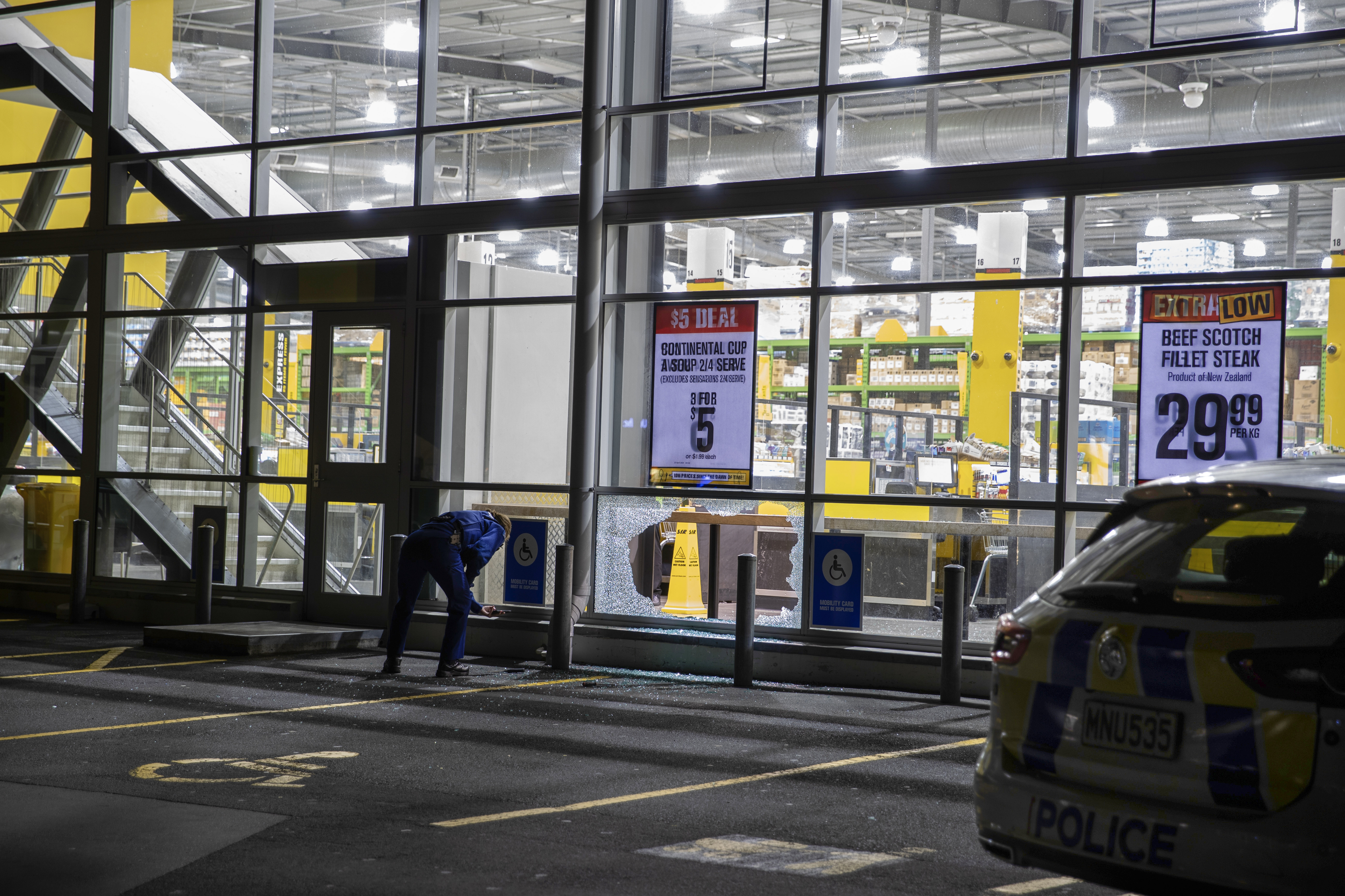 A police officer inspects the damage caused at a Pak'nSave Royal Oak supermarket, in April 2023. Photo / Hayden Woodward