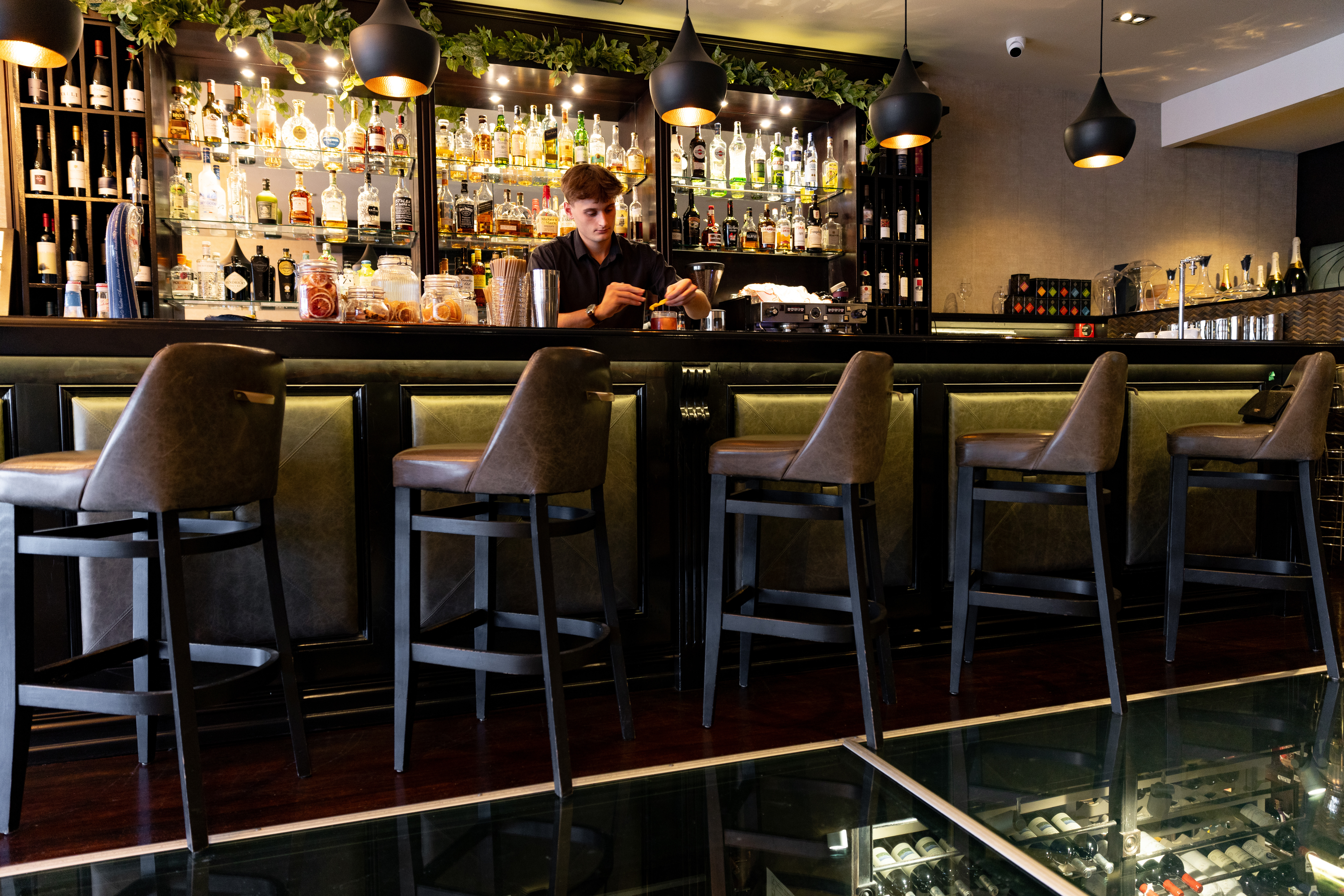 The bar features a glance of the wine cellar down below. Photo / Babiche Martens