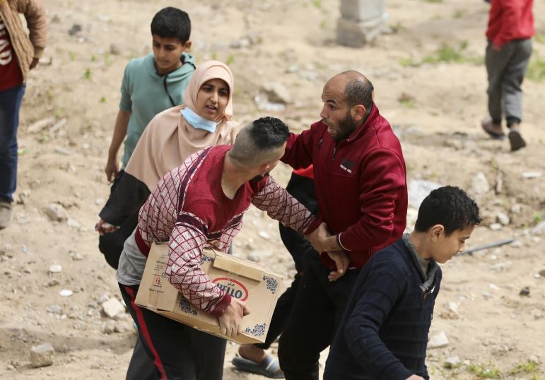 Palestinians rush to collect the humanitarian aid airdropped into Gaza City, Gaza Strip, on Sunday, March 17, 2024. (AP Photo/Mohammed Hajjar)