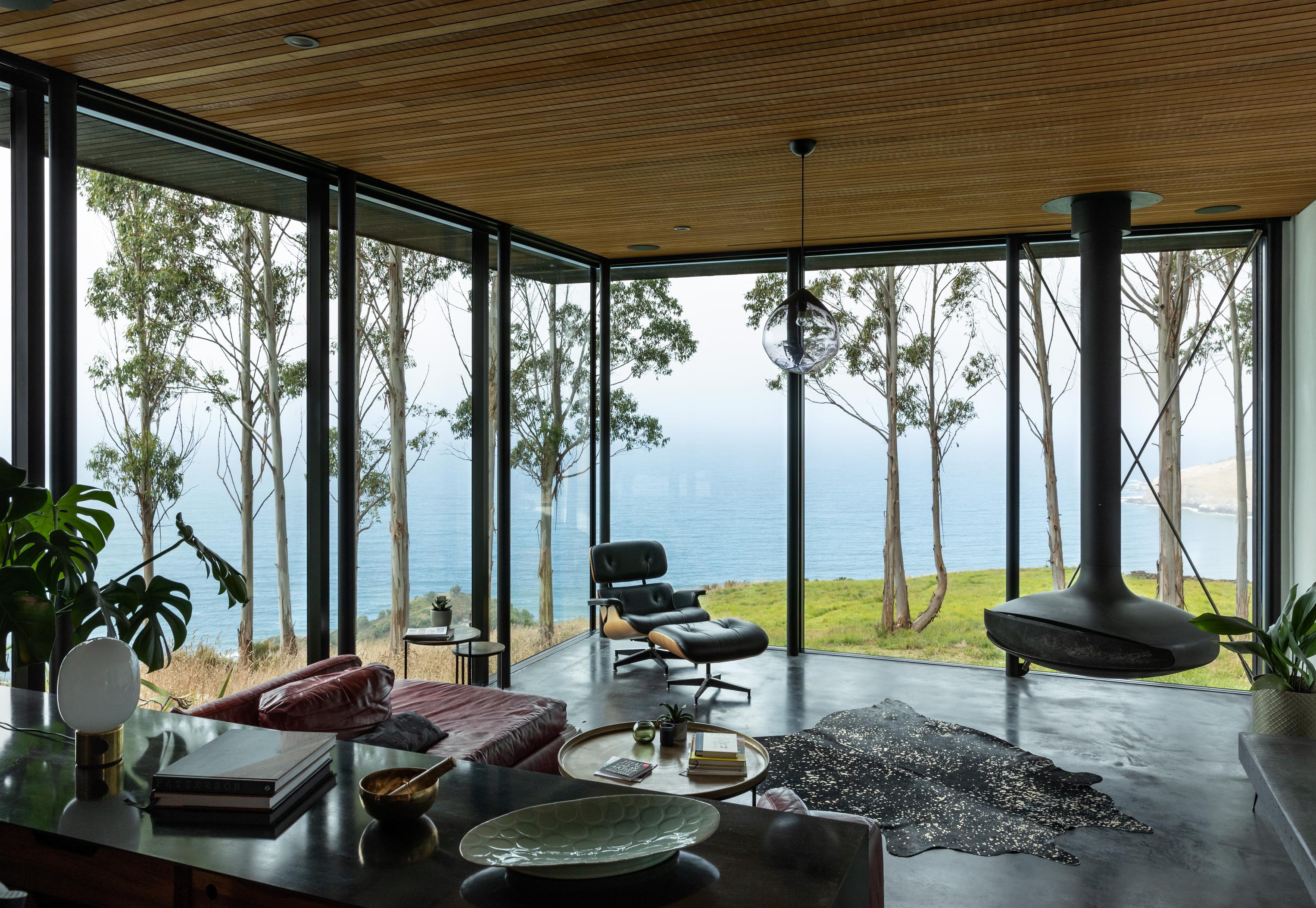 The living room drops two steps down, with wall-to-ceiling glass for an expansive view. Photo / Simon Devitt