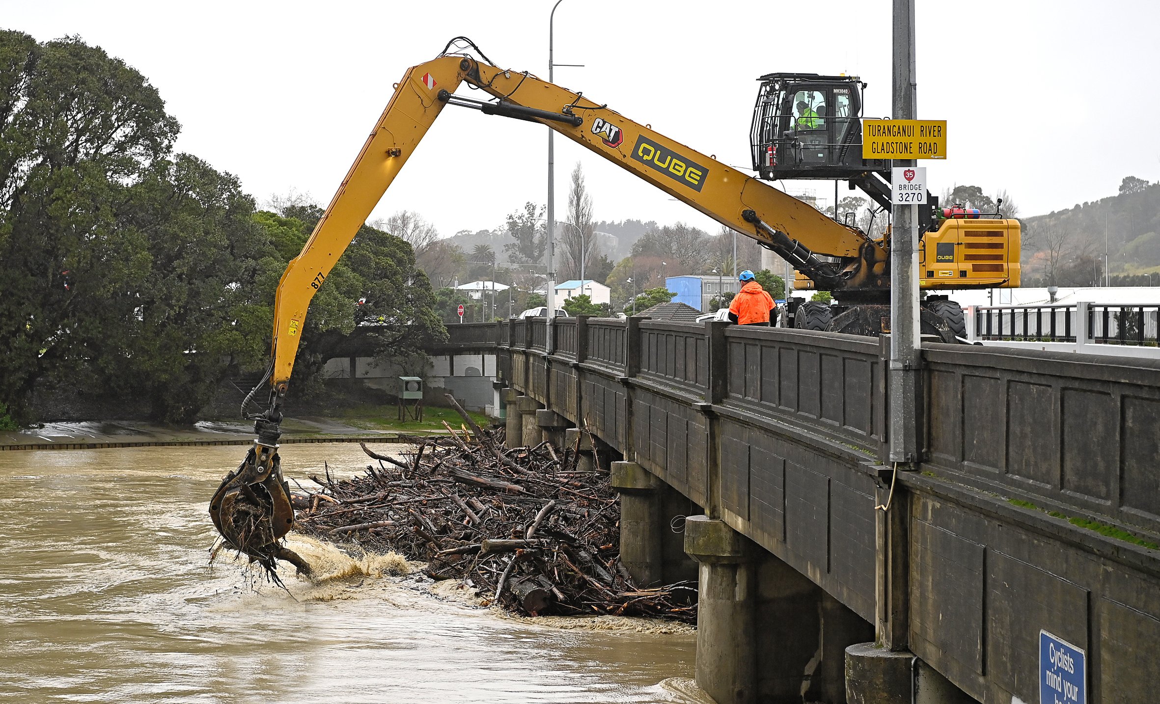 Woody debris being cleared from alongside Gladstone Rd Bridge at midday yesterday, as work began. Photo / Paul Rickard
