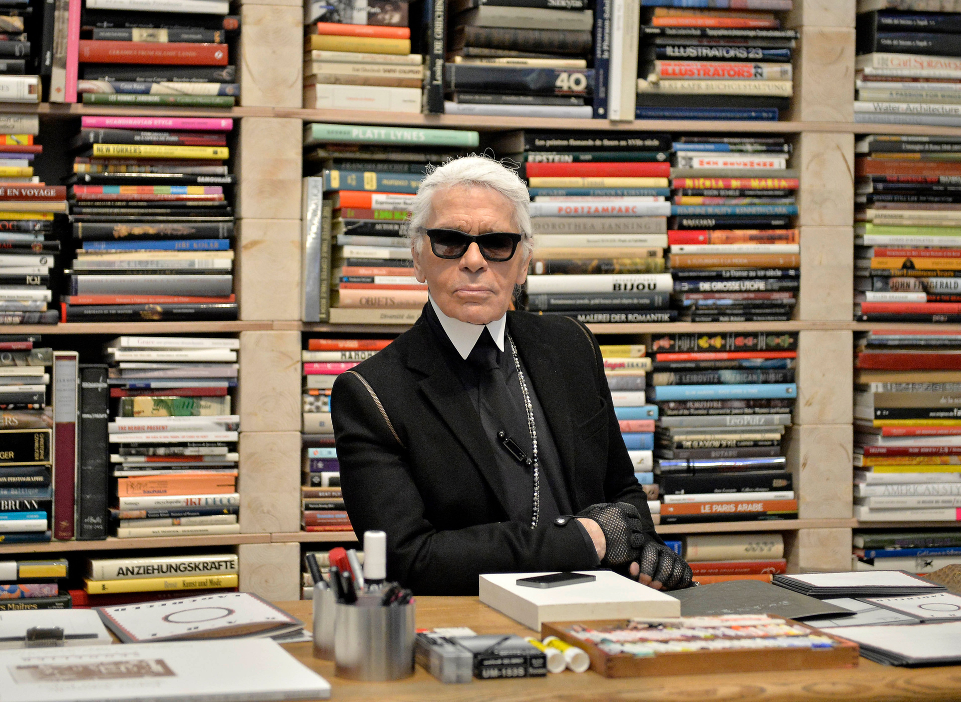 Lagerfeld poses for photographers in front of his books prior to the start of an exhibition at the museum Folkwang in Essen, Germany in 2014. Photo / AP