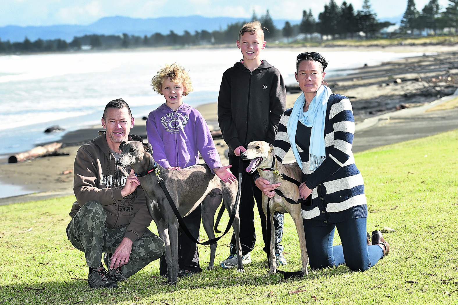 HARDLY 'WASTAGE': Kevin, Lennox, Theo and Nadine Weatherley are pictured with loving new family members Fox and Nikau, greyhound brothers who arrived from Invercargill in April after they were rejected from the racing industry because one did not chase the lure, and the other had an injury.