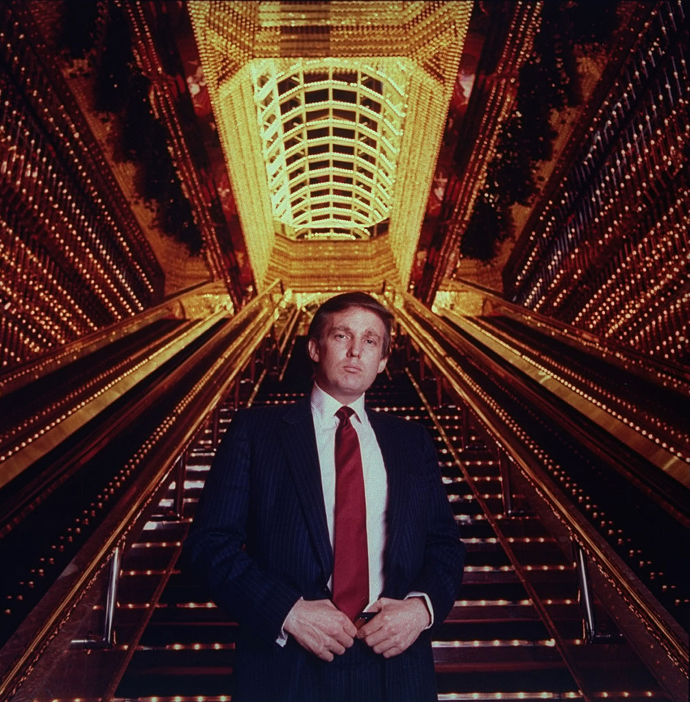 In his early days as a real estate tycoon, Donald Trump poses in the Trump Tower atrium. Photo / Getty Images