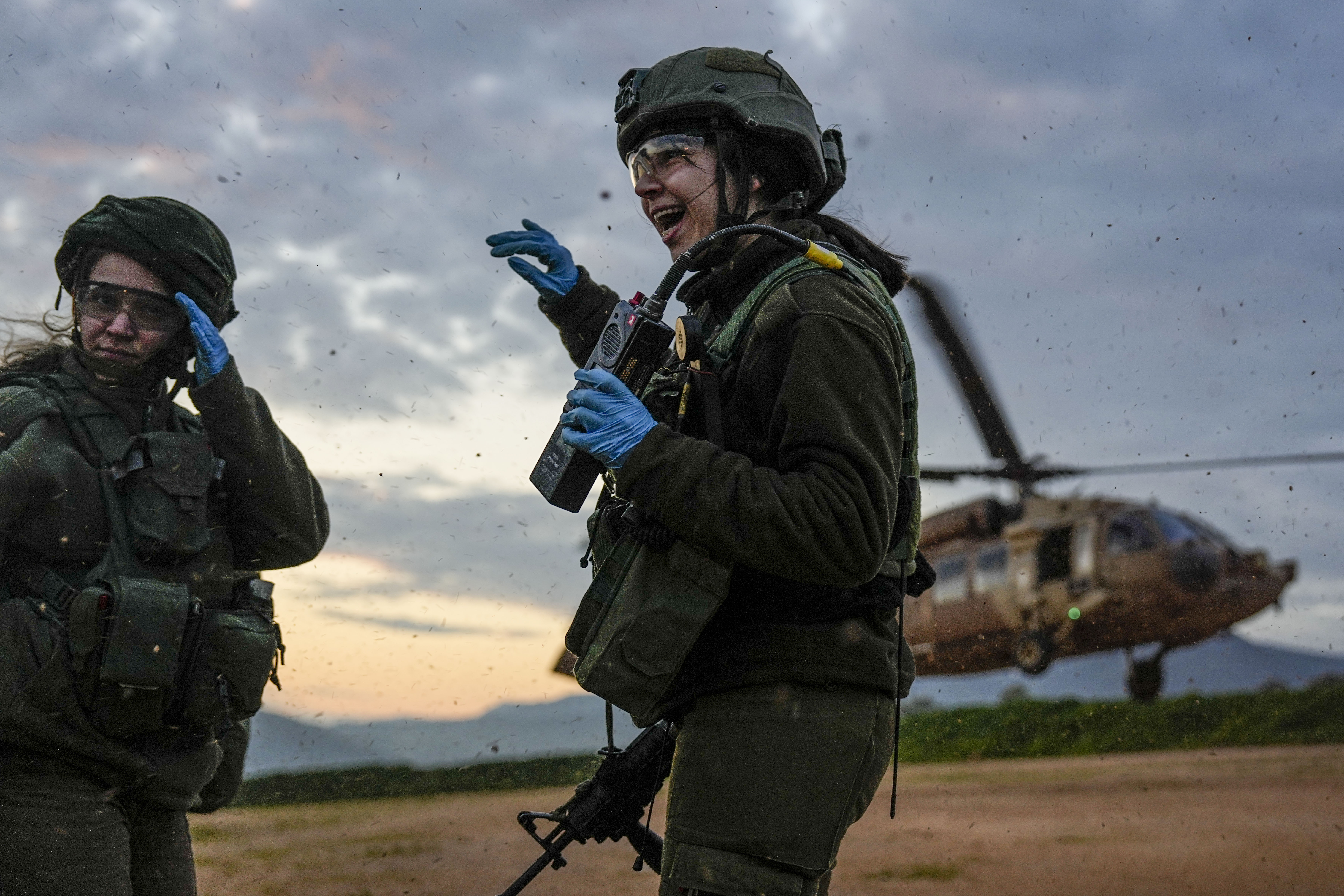 Israeli female paramedic soldiers take cover from the wind made by a landing military helicopter during an exercise simulating evacuation of wounded people in northern Israel, near the border with Lebanon. Photo / AP