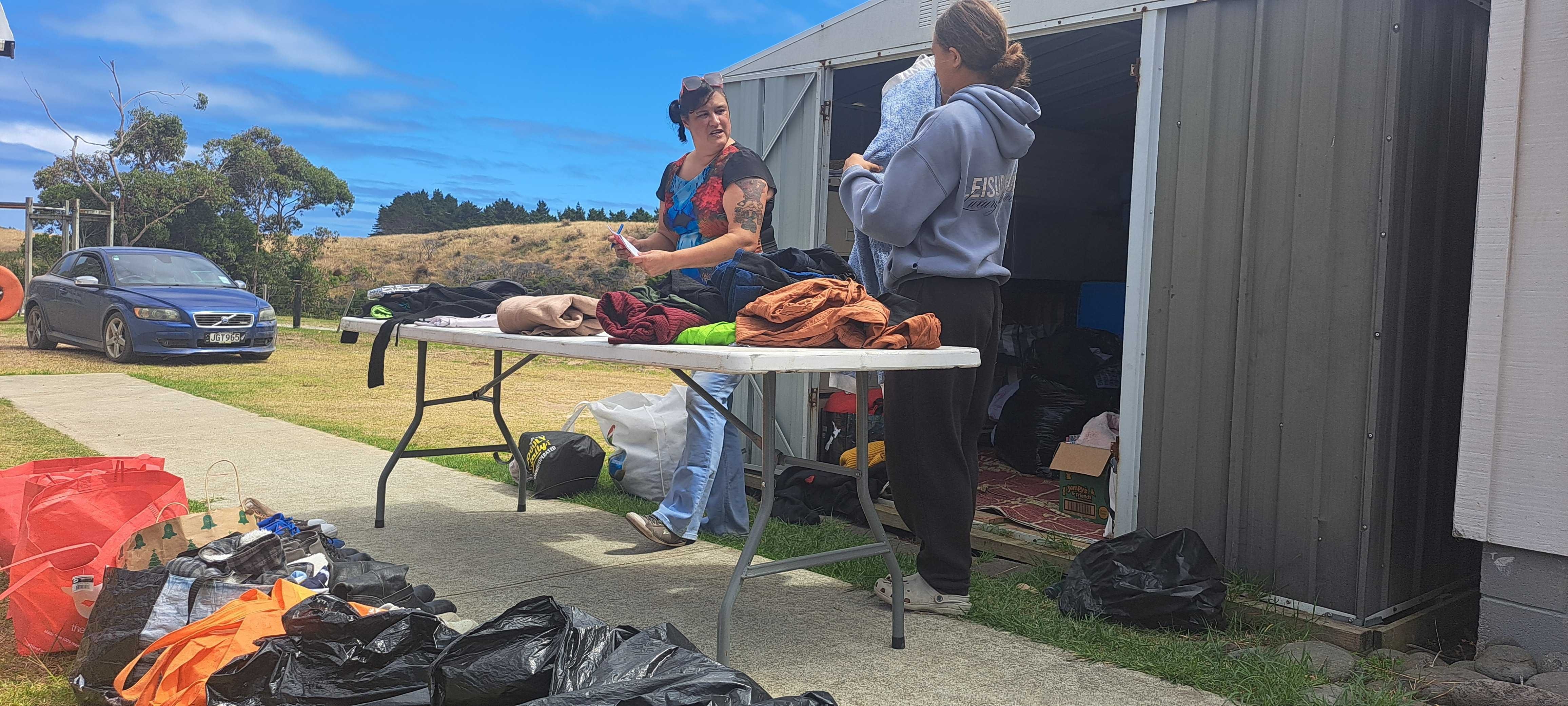 Volunteers April Dee and Amelia Chapman sort donations for people displaced from Waipoua Settlement during the huge scrub fire that threatened their homes last week.
