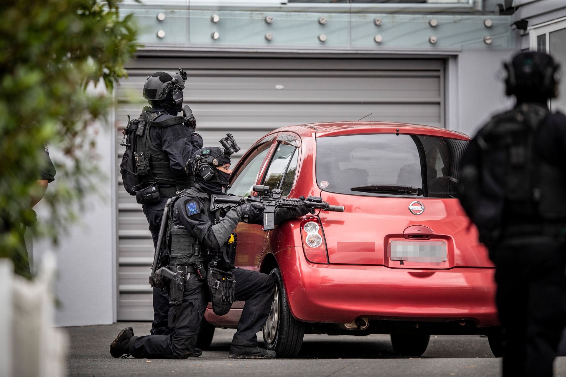 Armed police search Cliffview Rd, Green Bay, after an earlier homicide at the New Haven Motel, New Lynn. Photo / Michael Craig