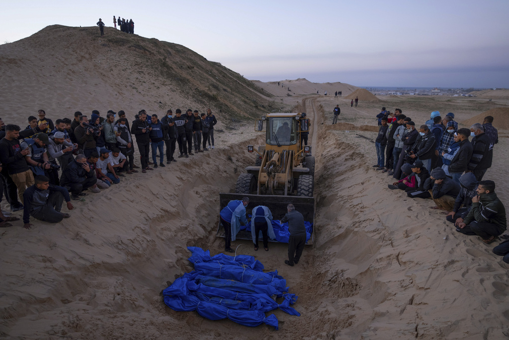A bulldozer unloads the bodies of Palestinians killed during a mass funeral in Rafah, Gaza Strip on December 26. Photo / AP