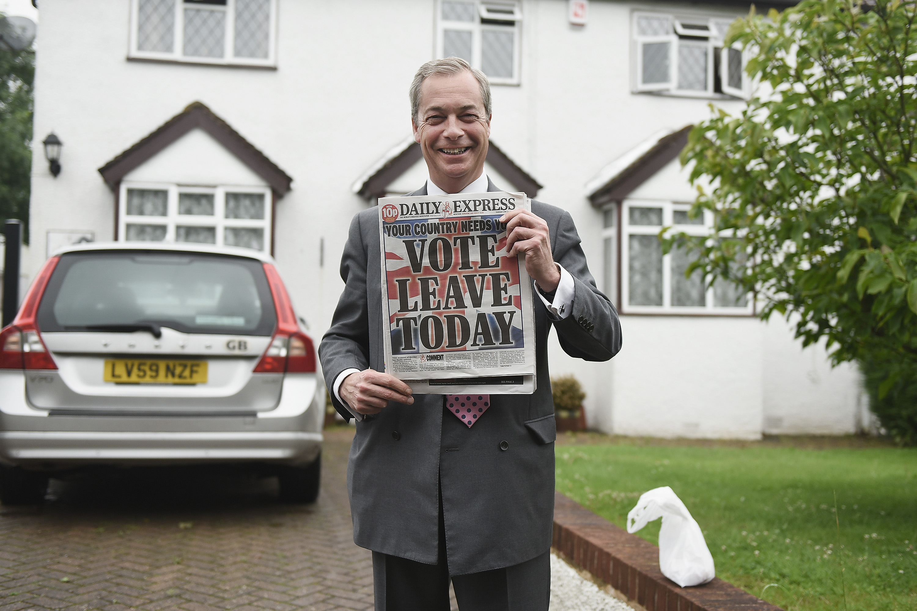 Nigel Farage holds up the 'Daily Express' as he returns to his home after buying newspapers of the United Kingdom before the EU referendum. Photo / Getty Images