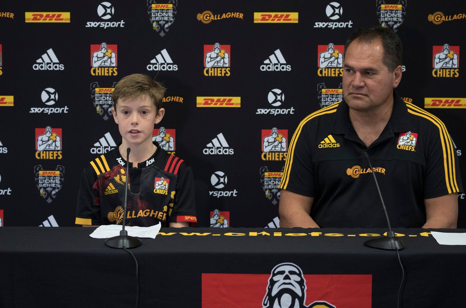 10 year-old Sam Webb announces the Chiefs side, along side coach Dave Rennie during a press conference, before the tour match between the British and Irish Lions in 2017. Photo / Brett Phibbs.