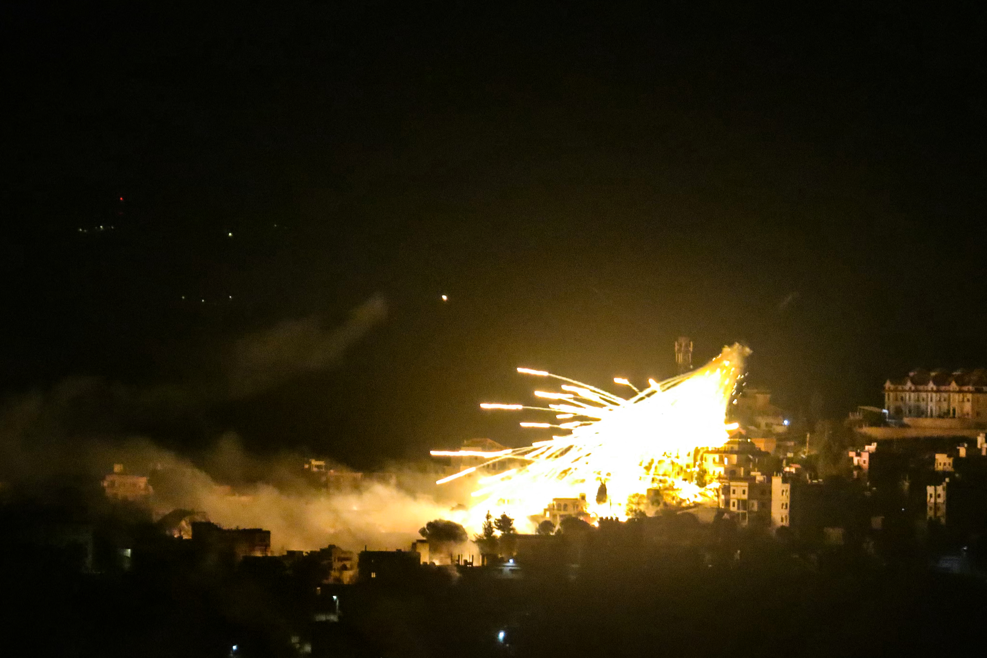 A picture taken from the area of Marjeyoun in southern Lebanon shows explosions over buildings in the town of Khiam, during Israeli bombardment on October 31, 2024. Photo / AFP