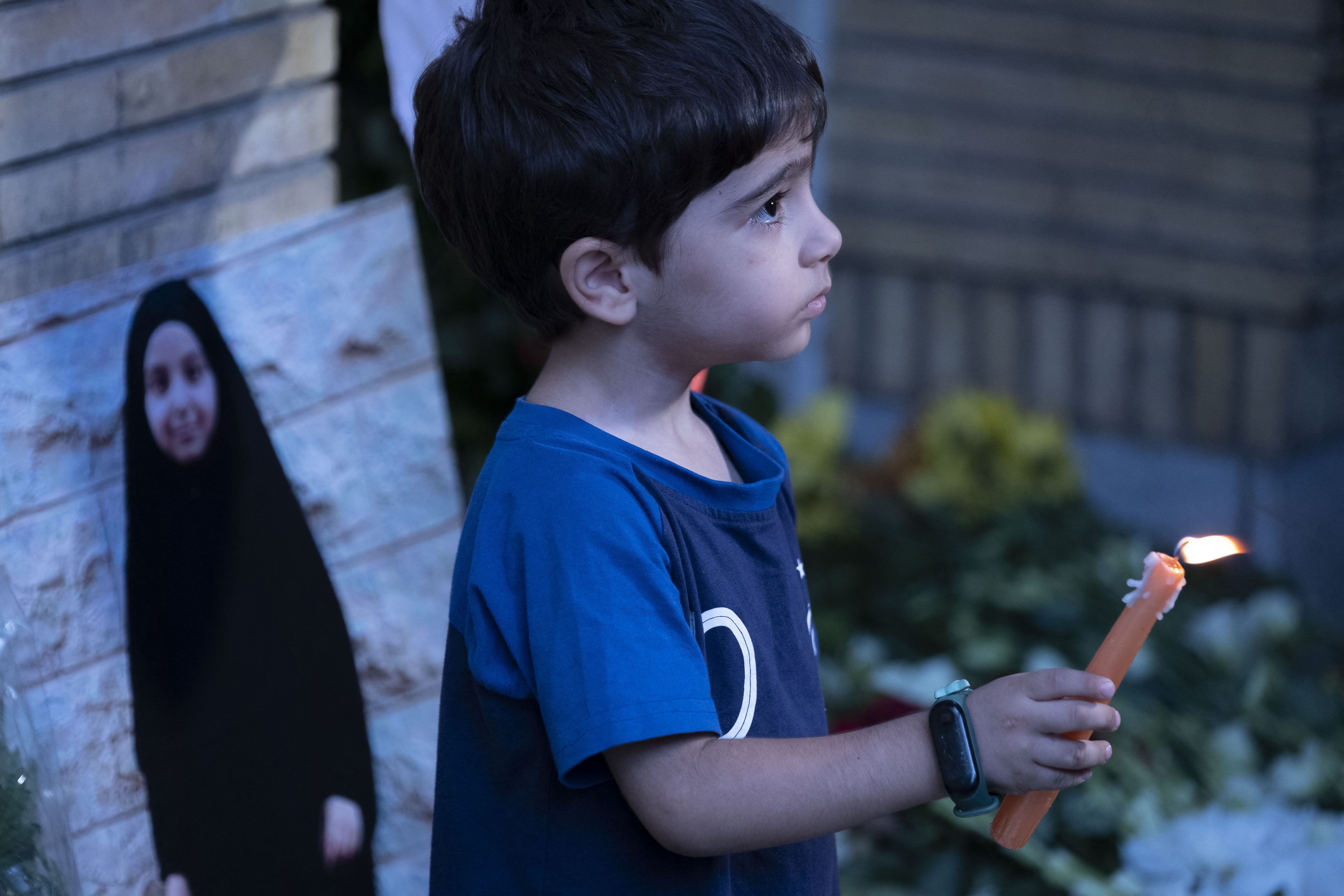 A young Iranian boy holds a candle next to a portrait of a young Lebanese girl who was killed in a deadly pager attack while standing in front of the Lebanese embassy in northern Tehran, Iran. Photo / AFP