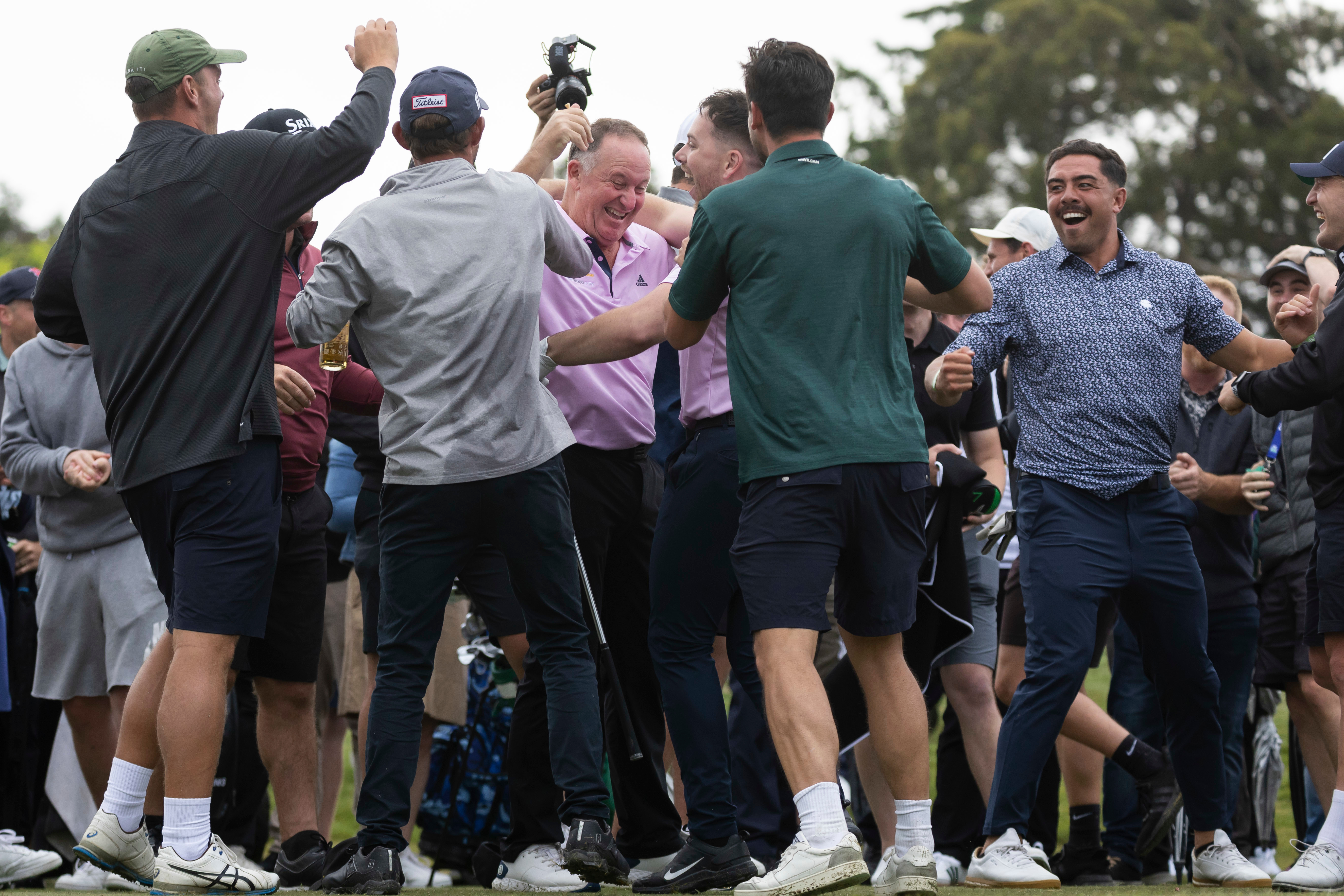 Sir John Key gets mobbed after his hole-in-one shot. Photo / Photosport