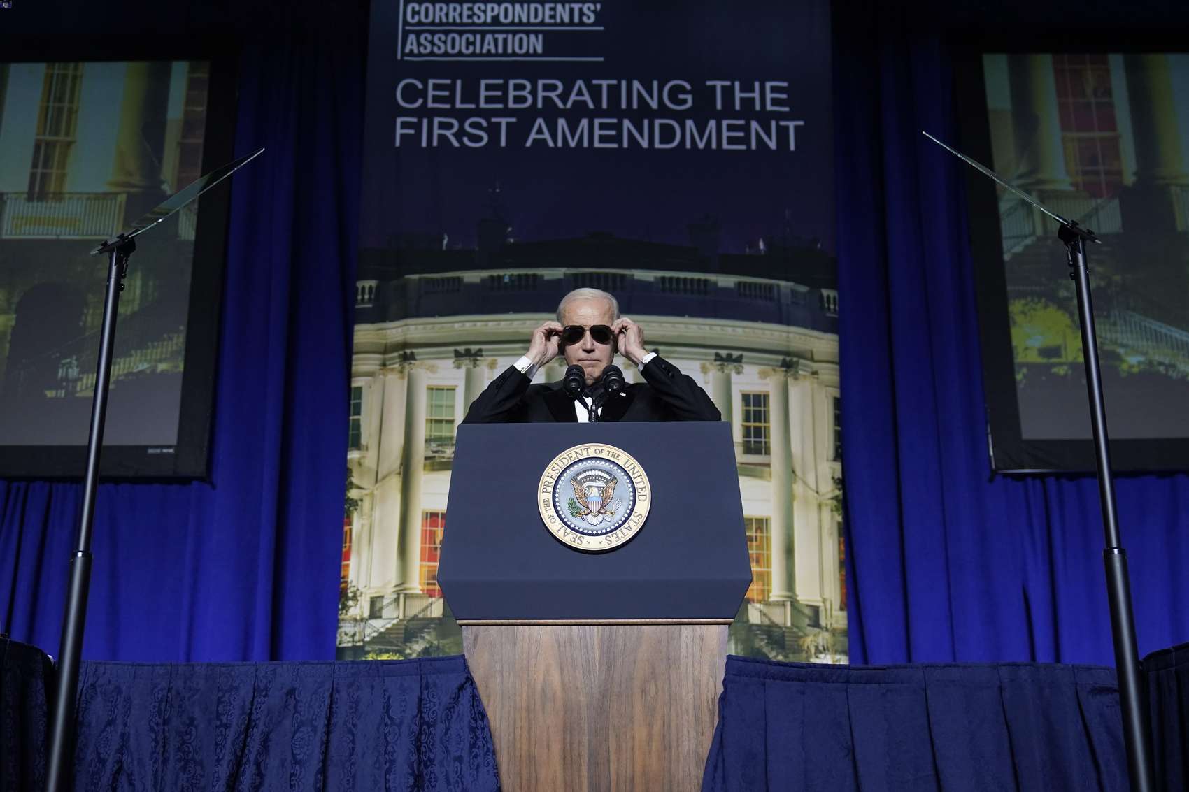 President Joe Biden puts on sunglasses after making a joke about becoming the