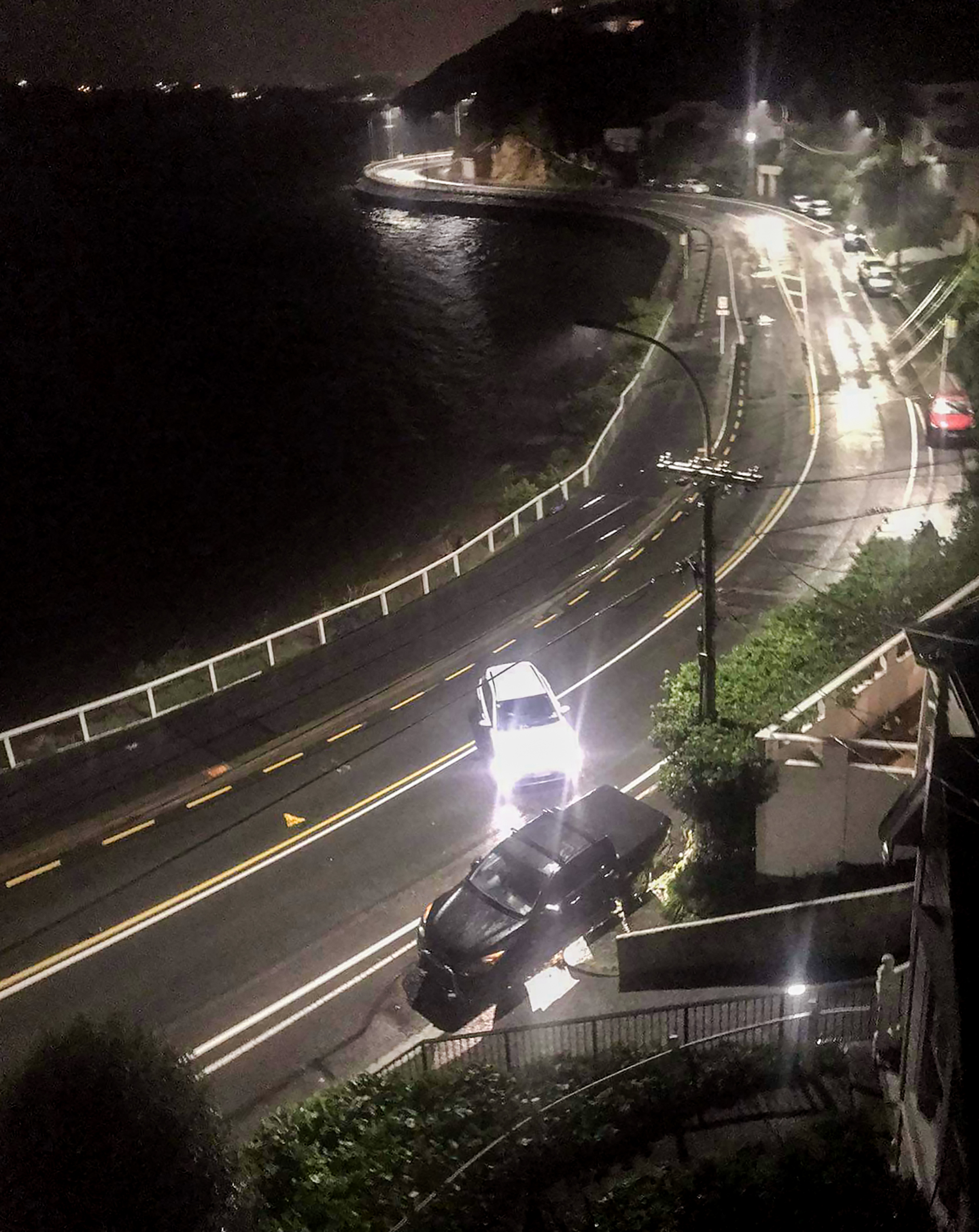 A white Hyundai Kona electric car provided driven by Kiri Allan sits on an angle, in the middle of Evans Bay Parade after the crash. 
