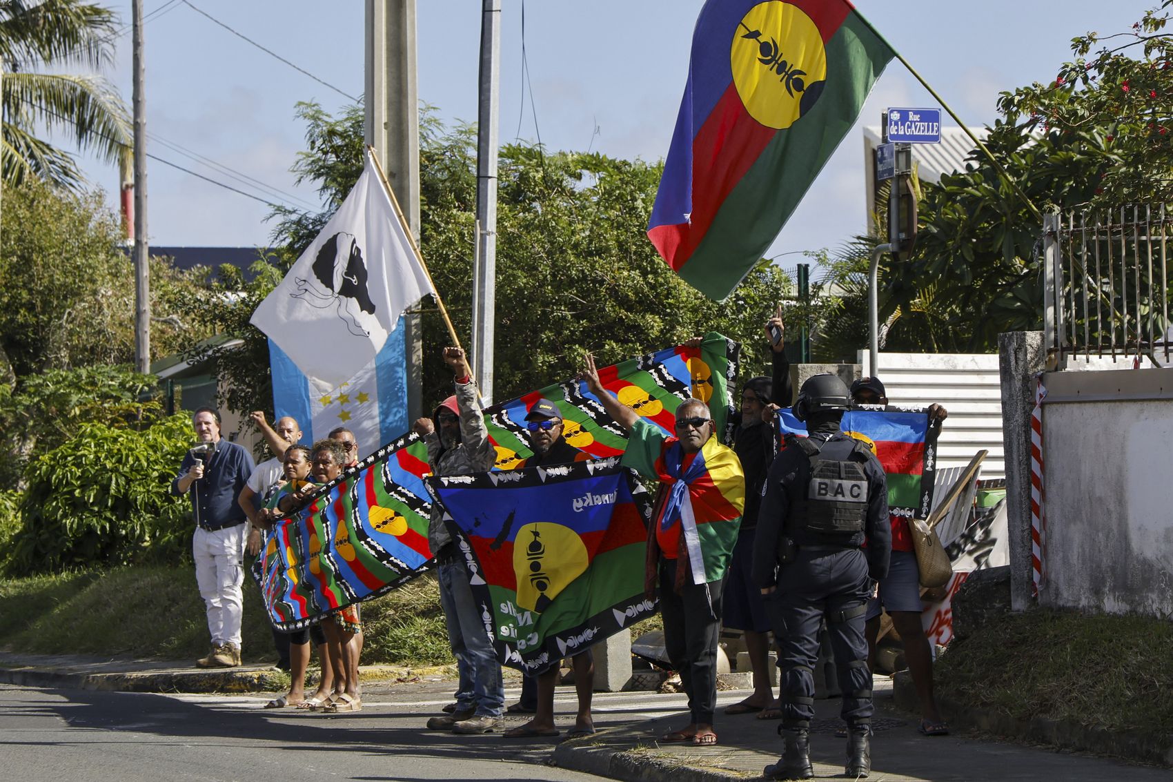 People demonstrate as French President Emmanuel Macron's motorcade drives past in Noumea, New Caledonia, on May 23. Photo / AP