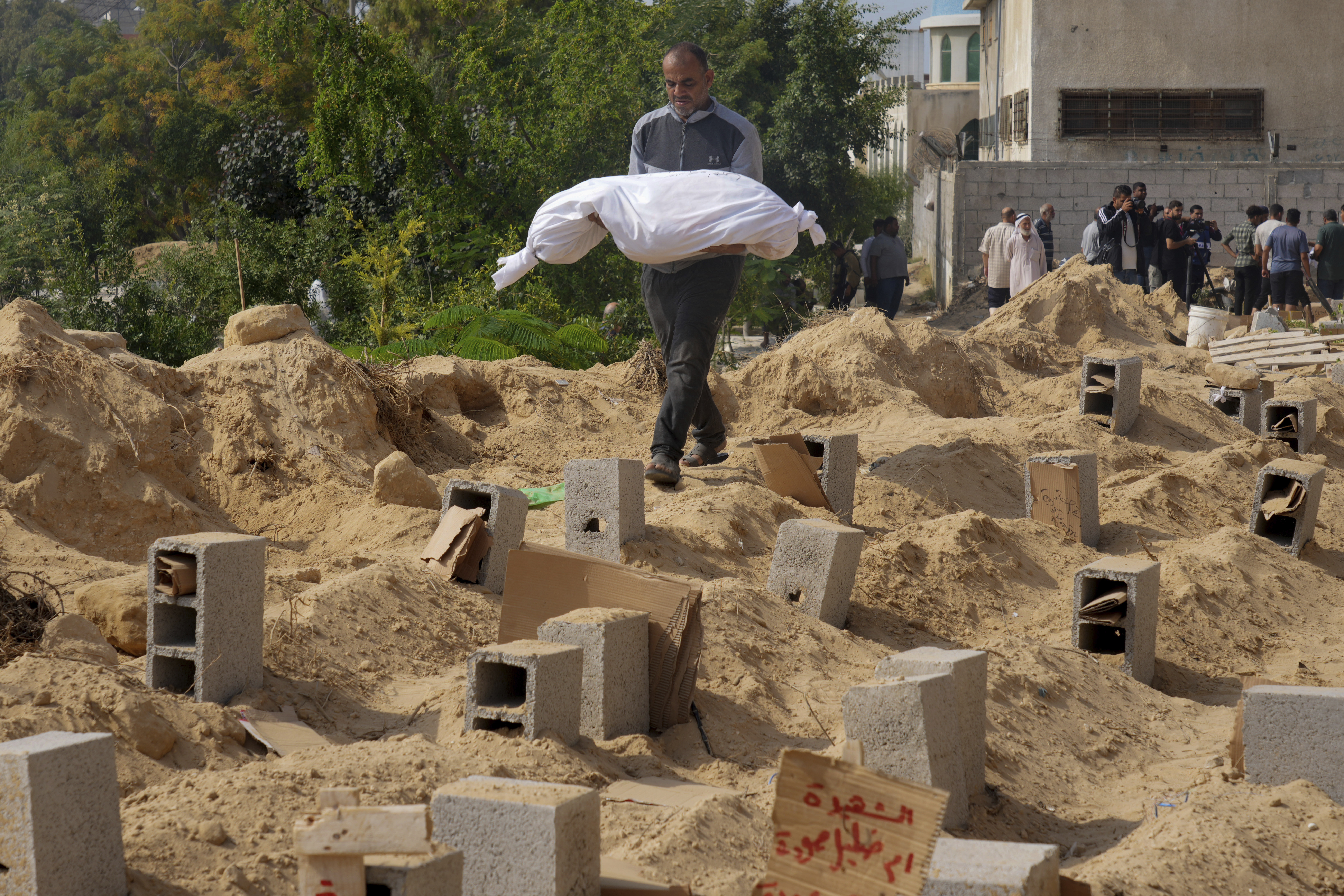 Palestinians bury the bodies of their relatives killed in the Israeli bombardment of the Gaza Strip, at a cemetery in Deir Al-Balah, Gaza. Photo / AP