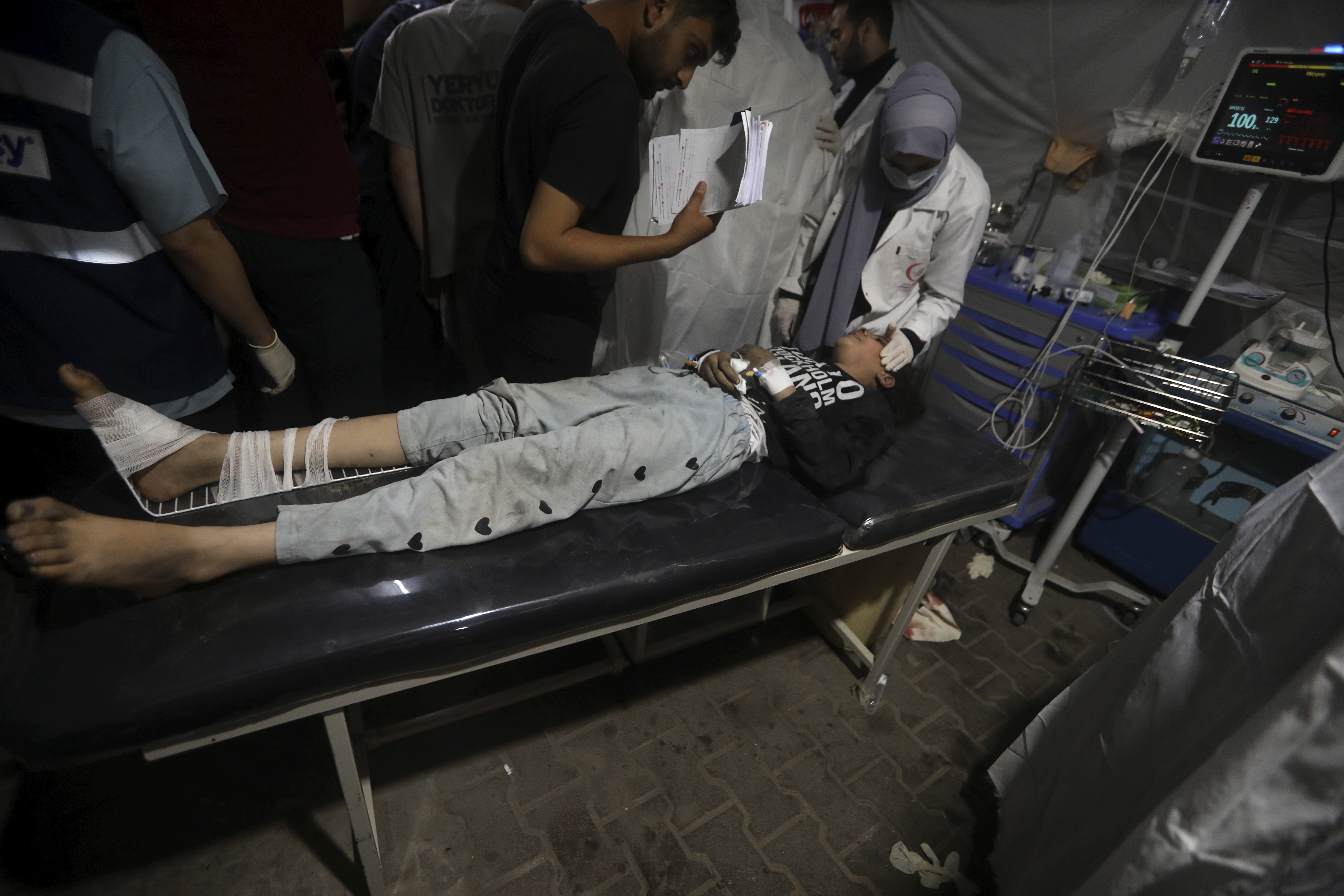 Palestinian medics treat a wounded in the Israeli bombardment of the Gaza Strip at the Kuwaiti Hospital in Rafah refugee camp, southern Gaza Strip. Photo / AP