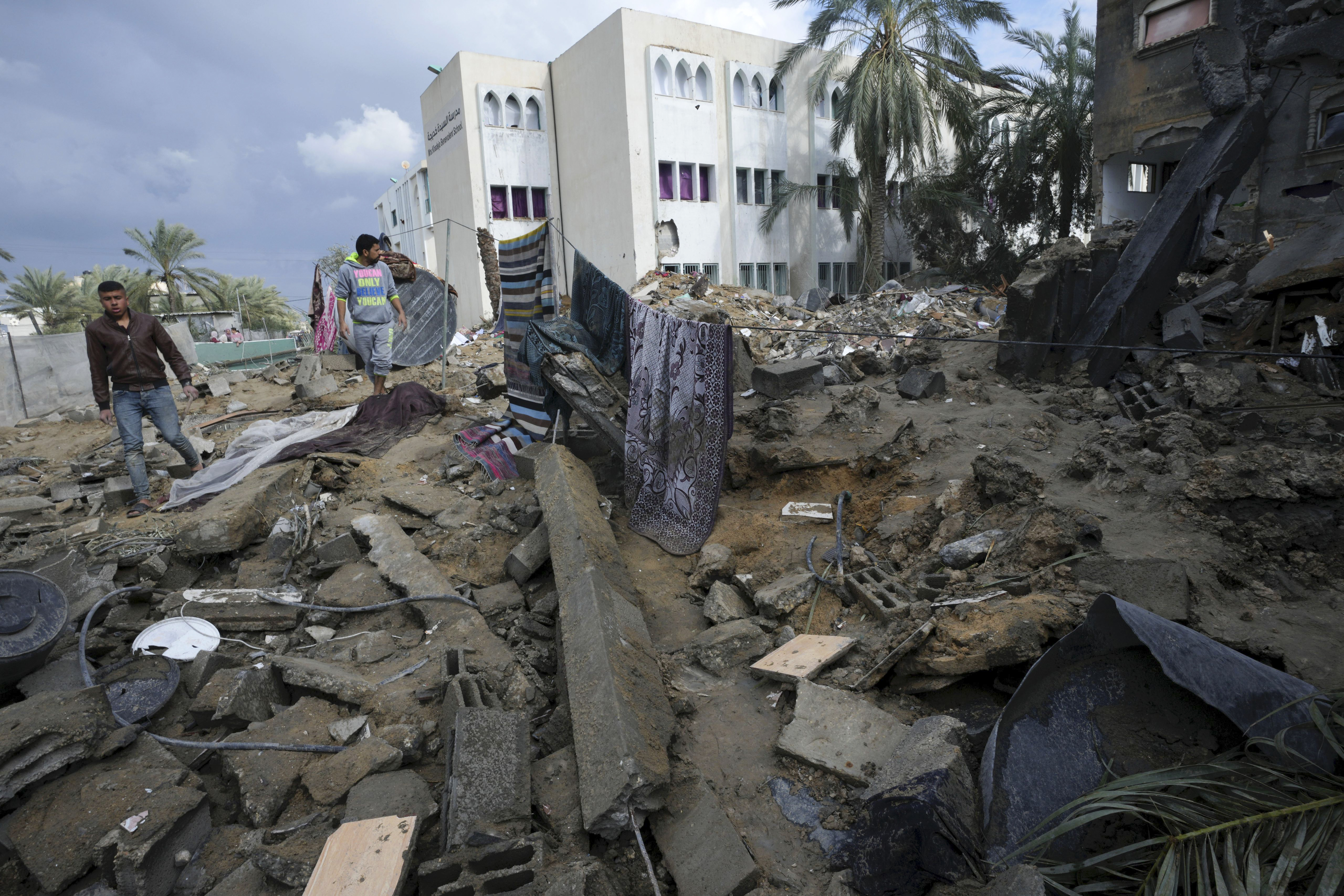 Palestinians look at the destruction after an Israeli strike at a residential building in Deir al Balah, Gaza Strip. Photo / AP