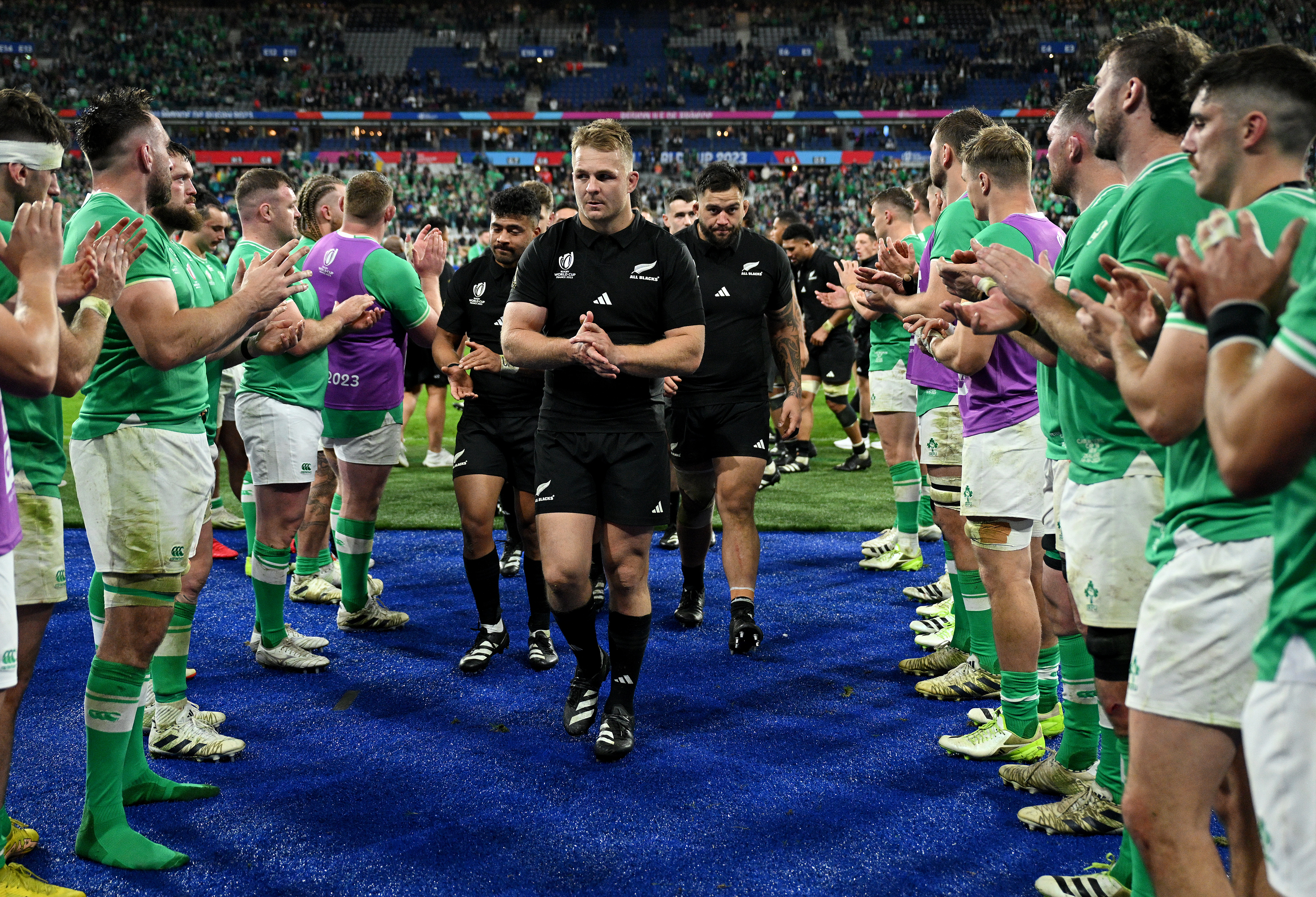 PARIS, FRANCE - OCTOBER 14: Sam Cane of New Zealand leads his teammates as they leave the field whilst the players of Ireland give the players of New Zealand a guard of honour at full-time following the Rugby World Cup France 2023 Quarter Final match between Ireland and New Zealand at Stade de France on October 14, 2023 in Paris, France. (Photo by David Ramos - World Rugby/World Rugby via Getty Images)