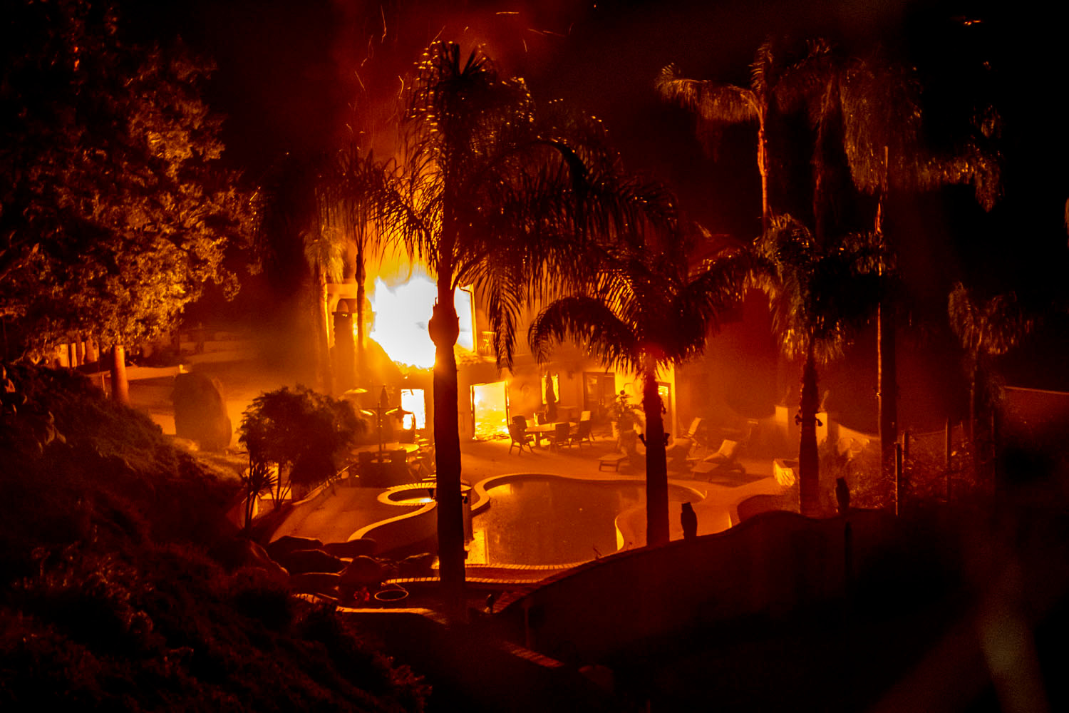Fire leaps through the windows of a consumed home in Malibu, California. Photo / Washington Post