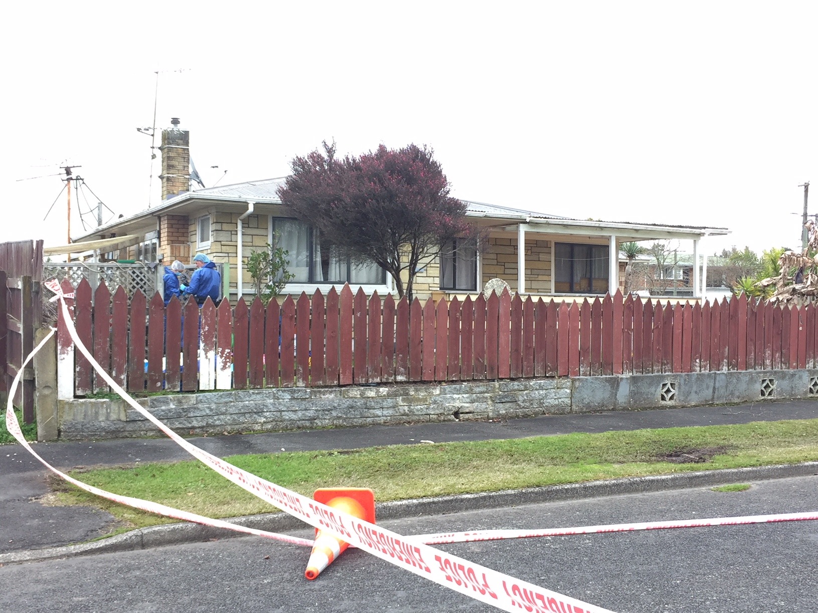 Forensic staff examine the house where Robert Nelson was shot dead. Gunmen knocked on the door of the front porch, pictured, before storming in and letting off a multitude of shots. Photo / Belinda Feek