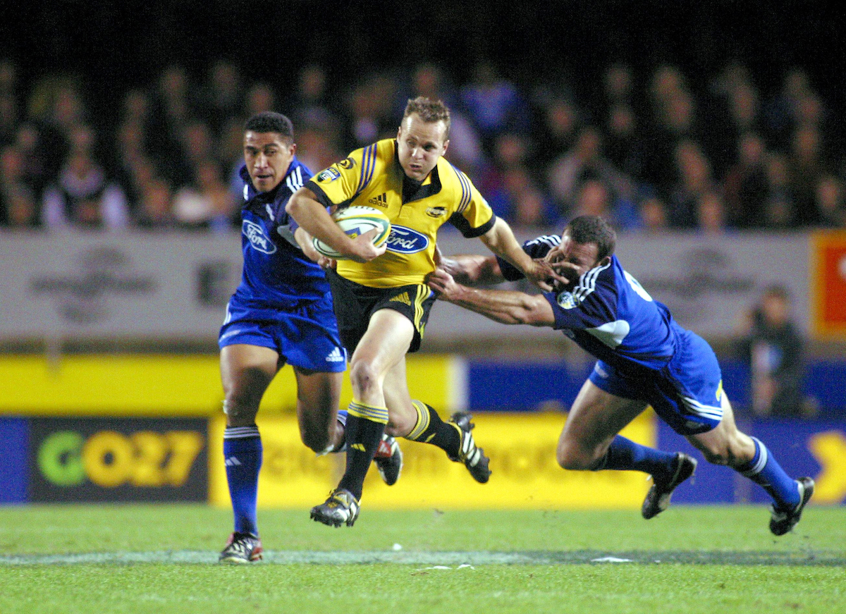 Christian Cullen breaks a tackle in a 2003 match against the Blues. Photosport