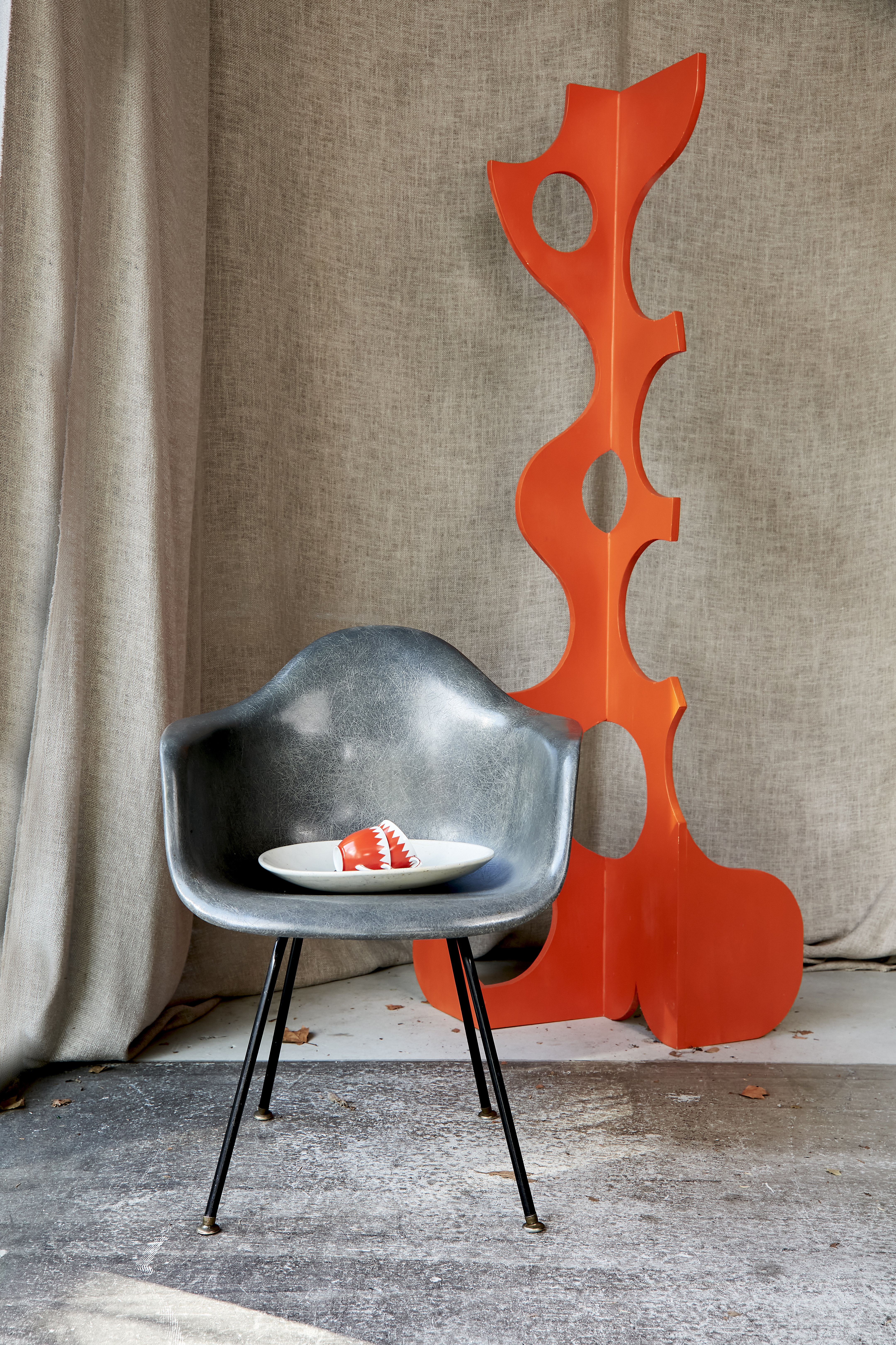 In the shop, an orange sculpture by local artist Grant Gallagher, the grey Eames chair is an original fibreglass model from early production and the ceramics are vintage. Photo / Babiche Martens