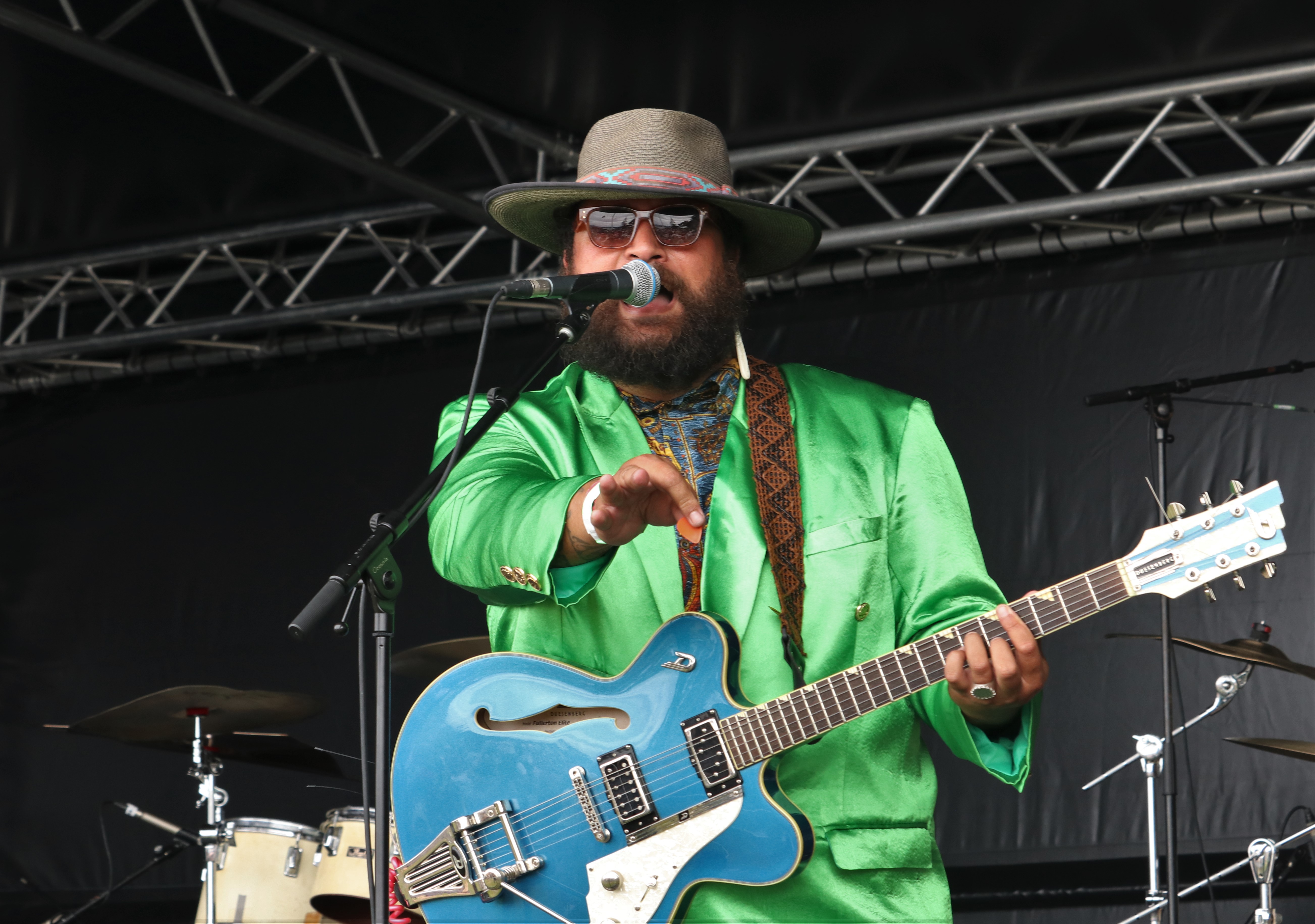 Kerikeri’s Troy Kingi, resplendent in a green suit, performs on the Treaty Grounds stage from his latest 1980s-style synth pop album. Photo / Peter de Graaf