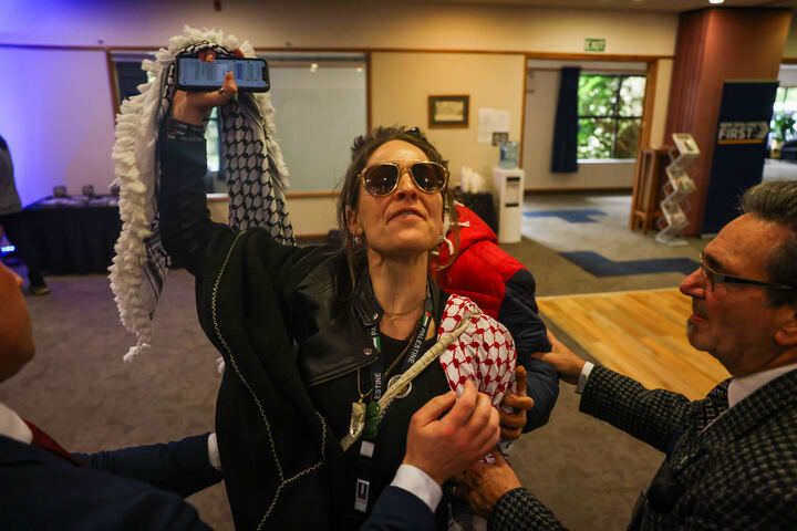 A protester disrupts New Zealand First leader Winston Peters' speech today during the party's national convention in Hamilton. Photo / Mike Scott