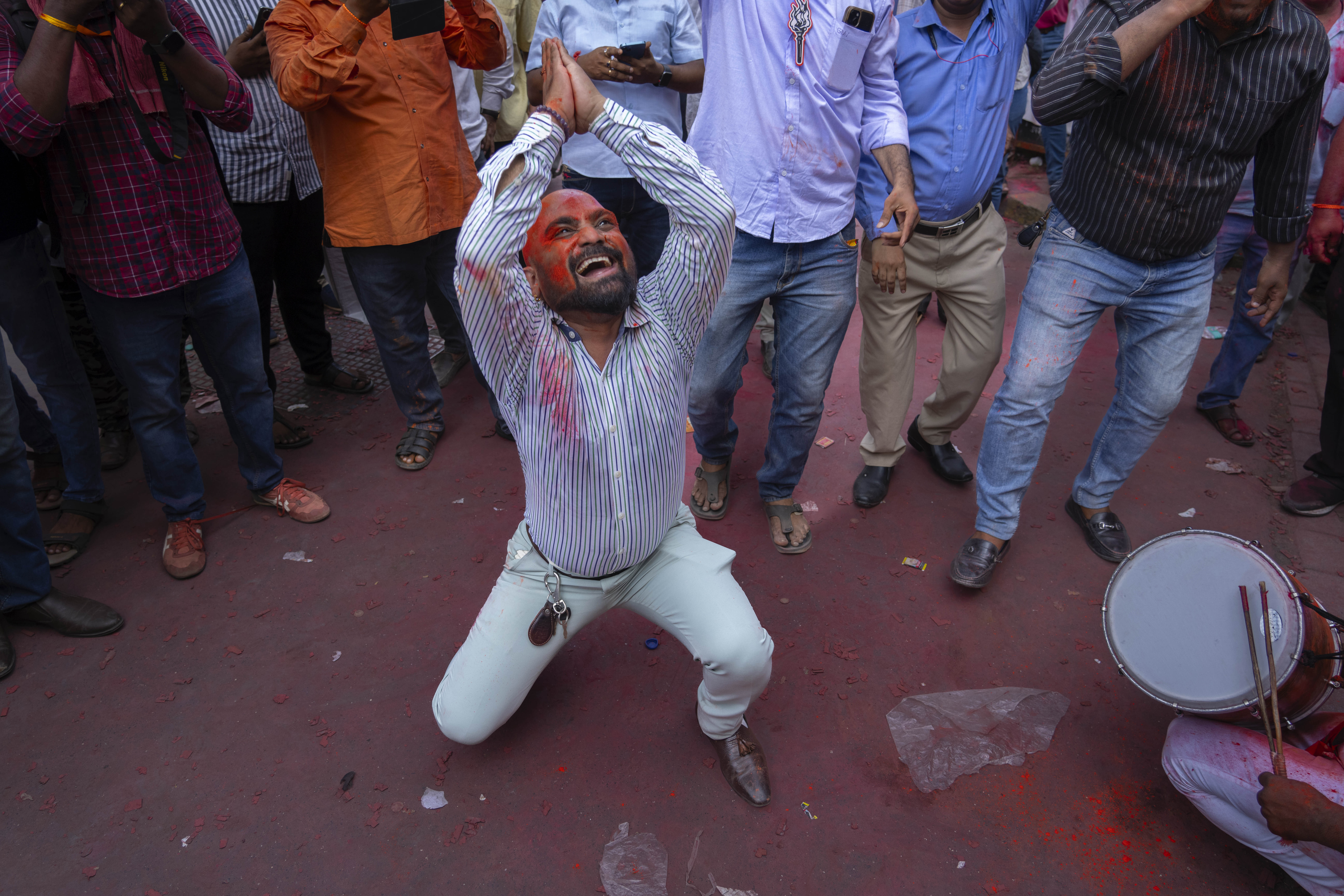 A supporter of Shiv Sena (Uddhav Balasaheb Thackeray) dances as he and others celebrate their party's lead. Photo / AP