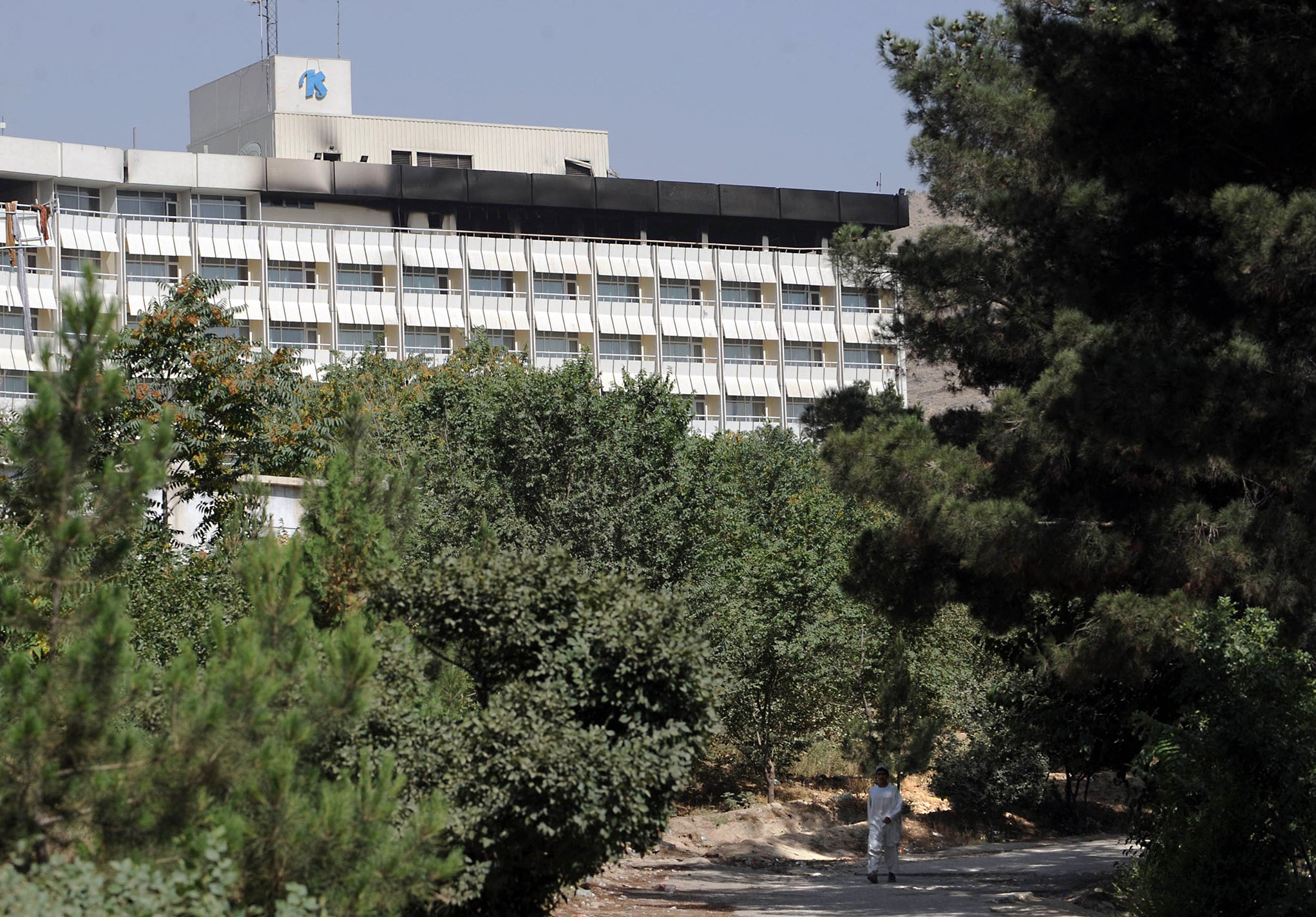 An Afghan man walks past the Intercontinental Hotel the day after the deadly attack by Taliban fighters. Photo / AFP