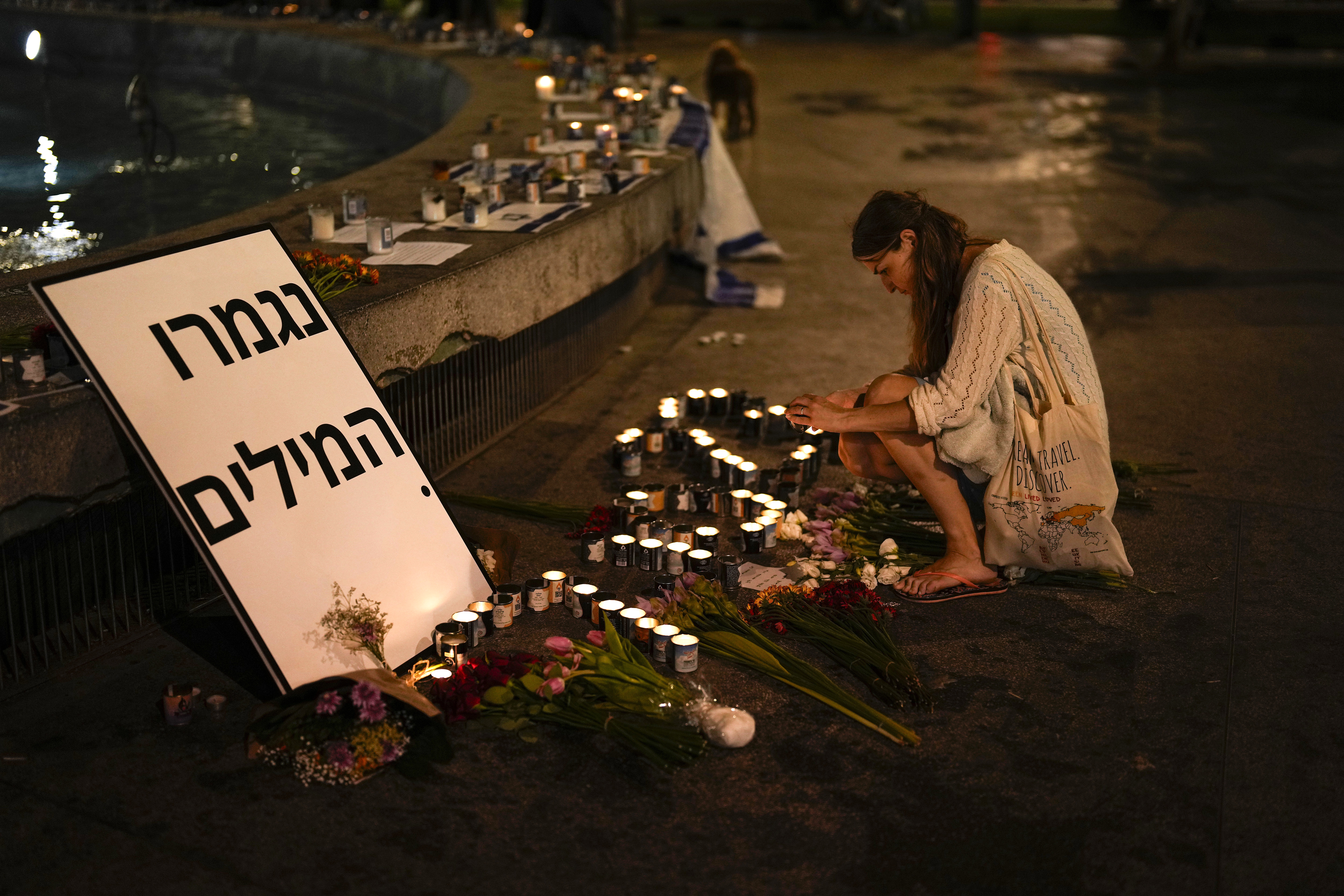 A woman lights candles in honour of victims of the Hamas attacks. Photo / AP