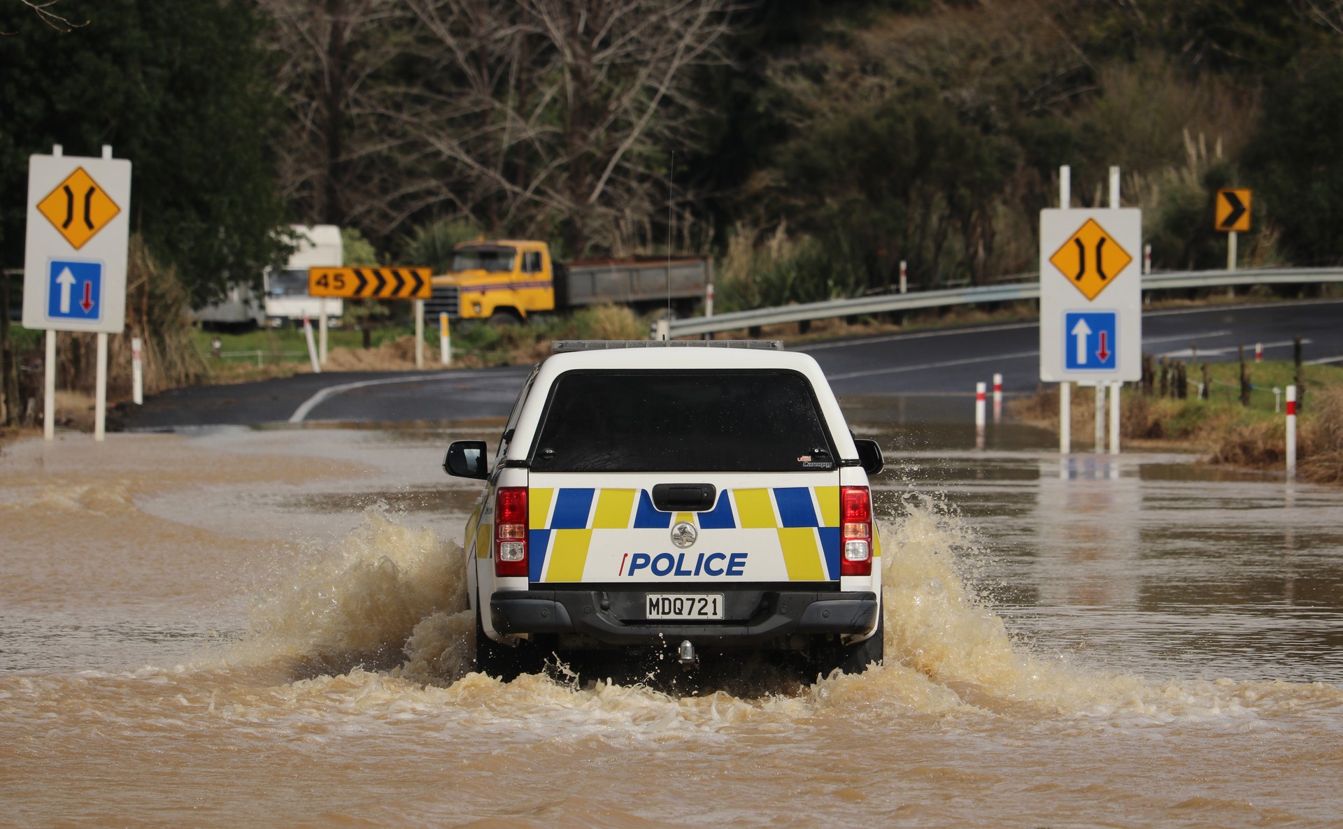 A police ute negotiates floodwaters on State Highway 1 at Rangiahua, between Okaihau and Mangamuka. Photo / Peter de Graaf 
