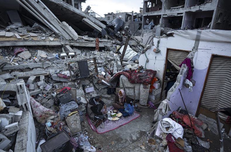 Members of the Al-Rabaya family break their fast during the Muslim holy month of Ramadan outside their destroyed home by the Israeli airstrikes in Rafah. Photo / AP